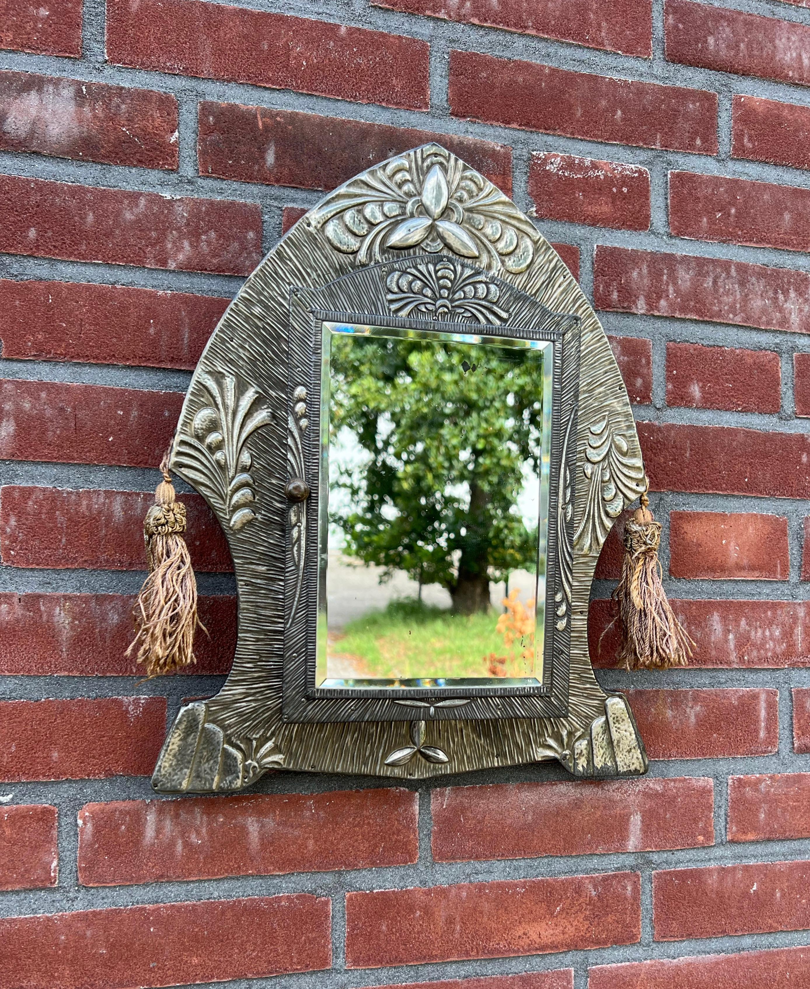 Great quality and condition wall key or brush cabinet from 1930.

This Arts & Crafts style wall cabinet can be used for all kinds of purposes and the stunning, beveled mirror is a real bonus. The handcrafted artwork in the form of carefully