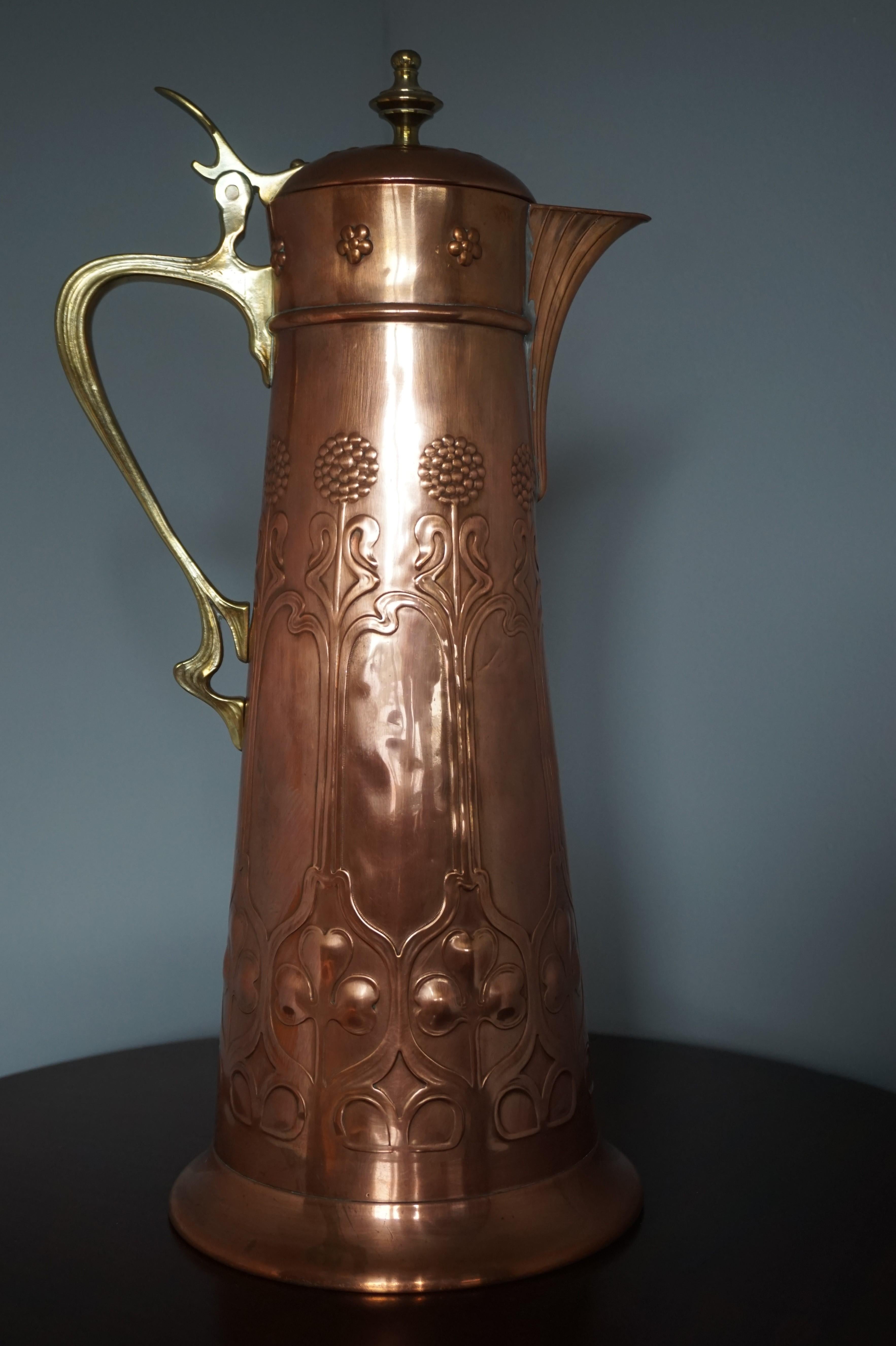 Wonderfully handcrafted WMF copper jug with brass handles.

This good size and wonderful shape Arts & Crafts jug was all-handcrafted (and marked) by the famous German makers WMF. Both the overal design and the warm patina of this pouring jug make