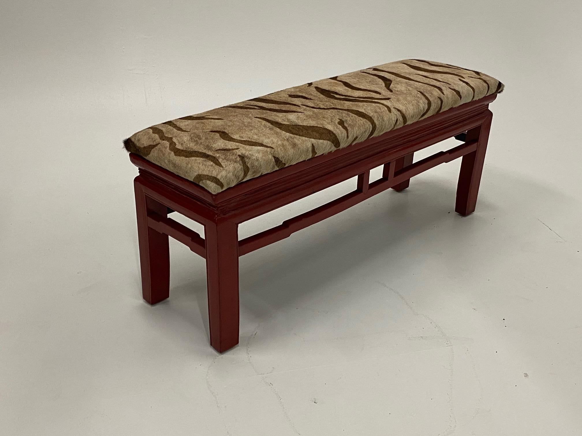 Super stylish cinnabar red Chinese lacquer bench with beautiful silhouette, recently updated with printed cowhide upholstery.