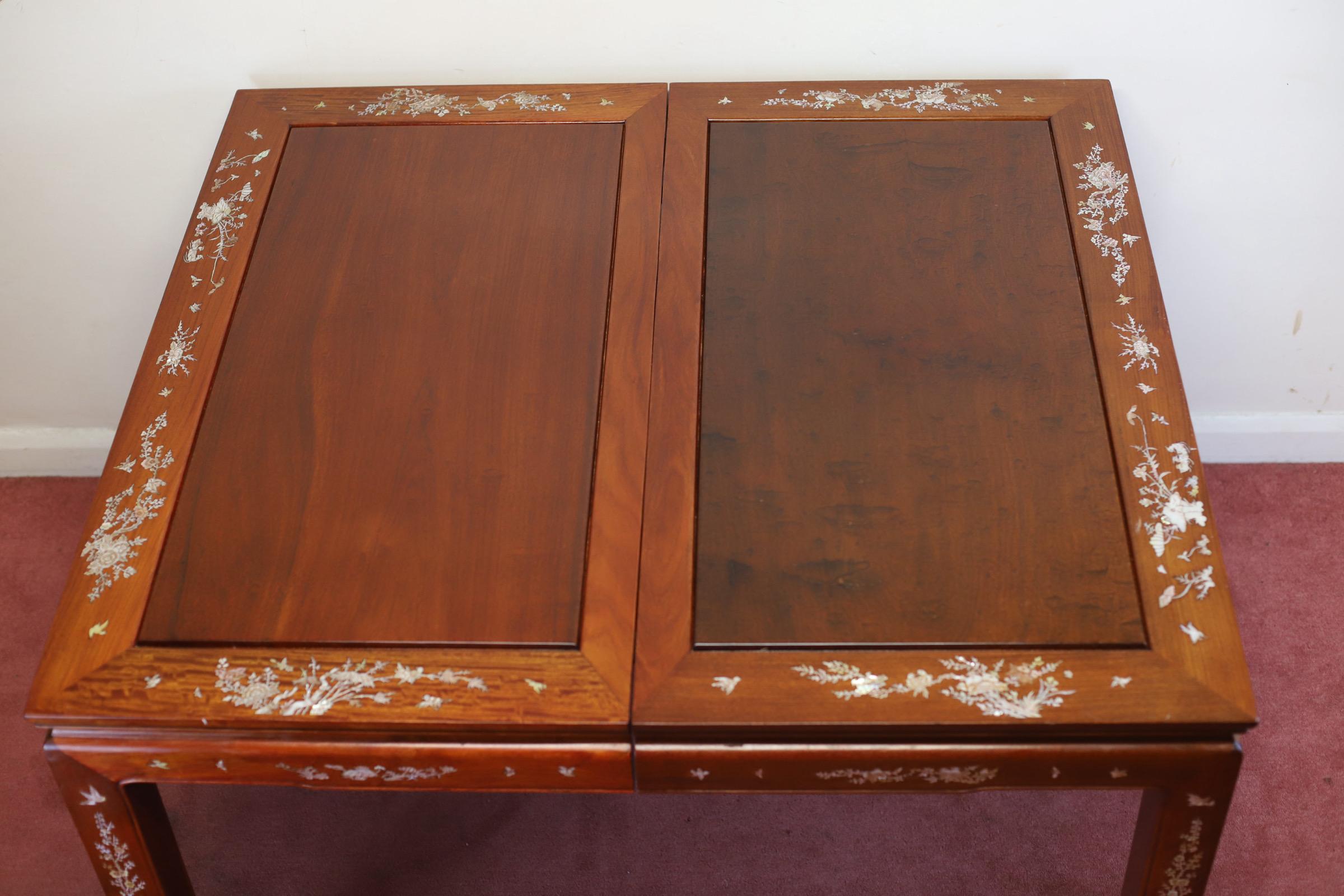We delight to offer for sale this stunning set of south East Asian hardwood and mother-of-pearl inset extending dining table, and eight chairs en suite, 20th century; the table with cleated panel top decorated with birds and foliage, with conforming