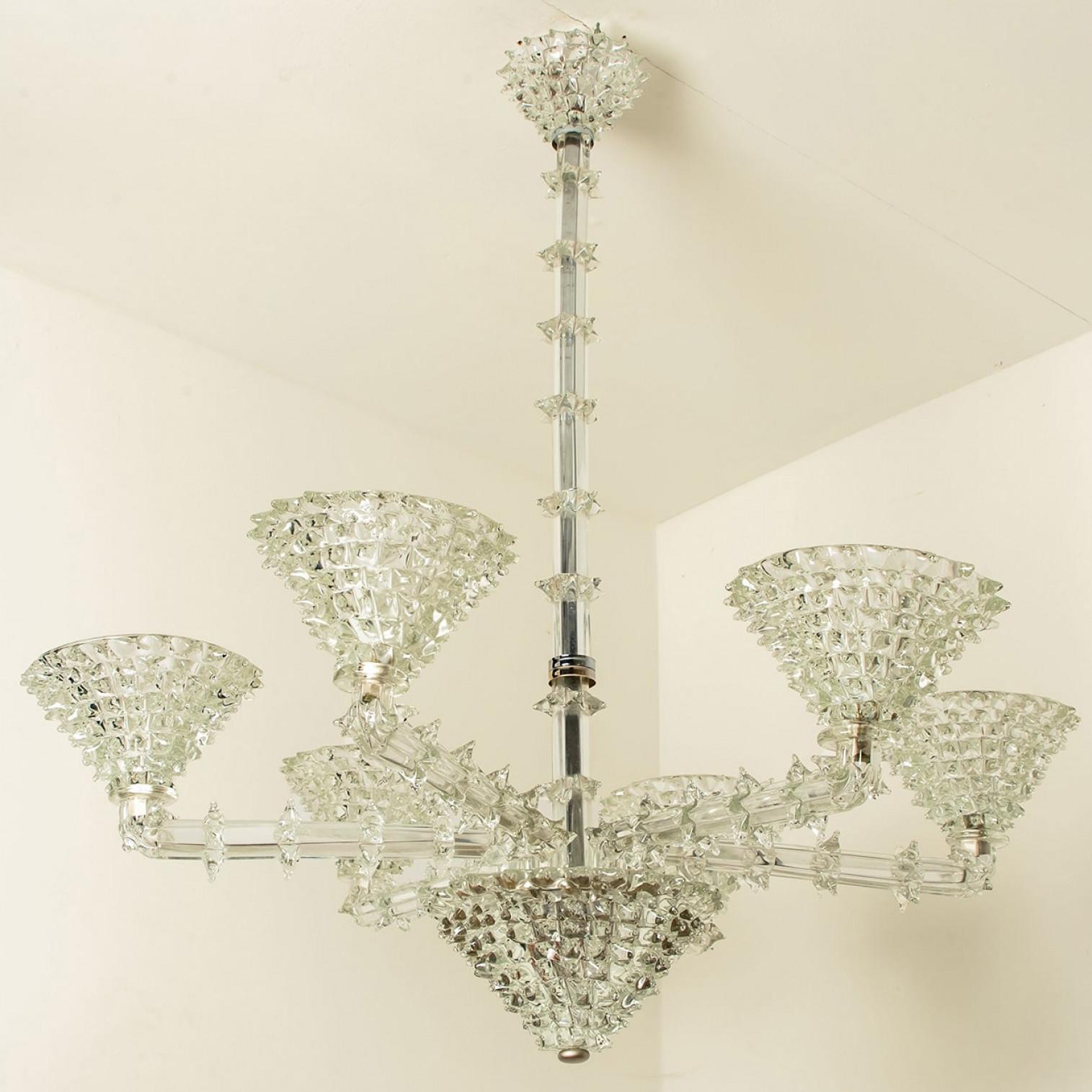 Impresionante lámpara de araña de seis brazos de Barovier & Toso, Italia, 1990. Esta pieza está hecha de cristal de murano, enriquecido con detalles cromados y delicados dibujos, que crean una luz juguetona y difusa. Ilumina