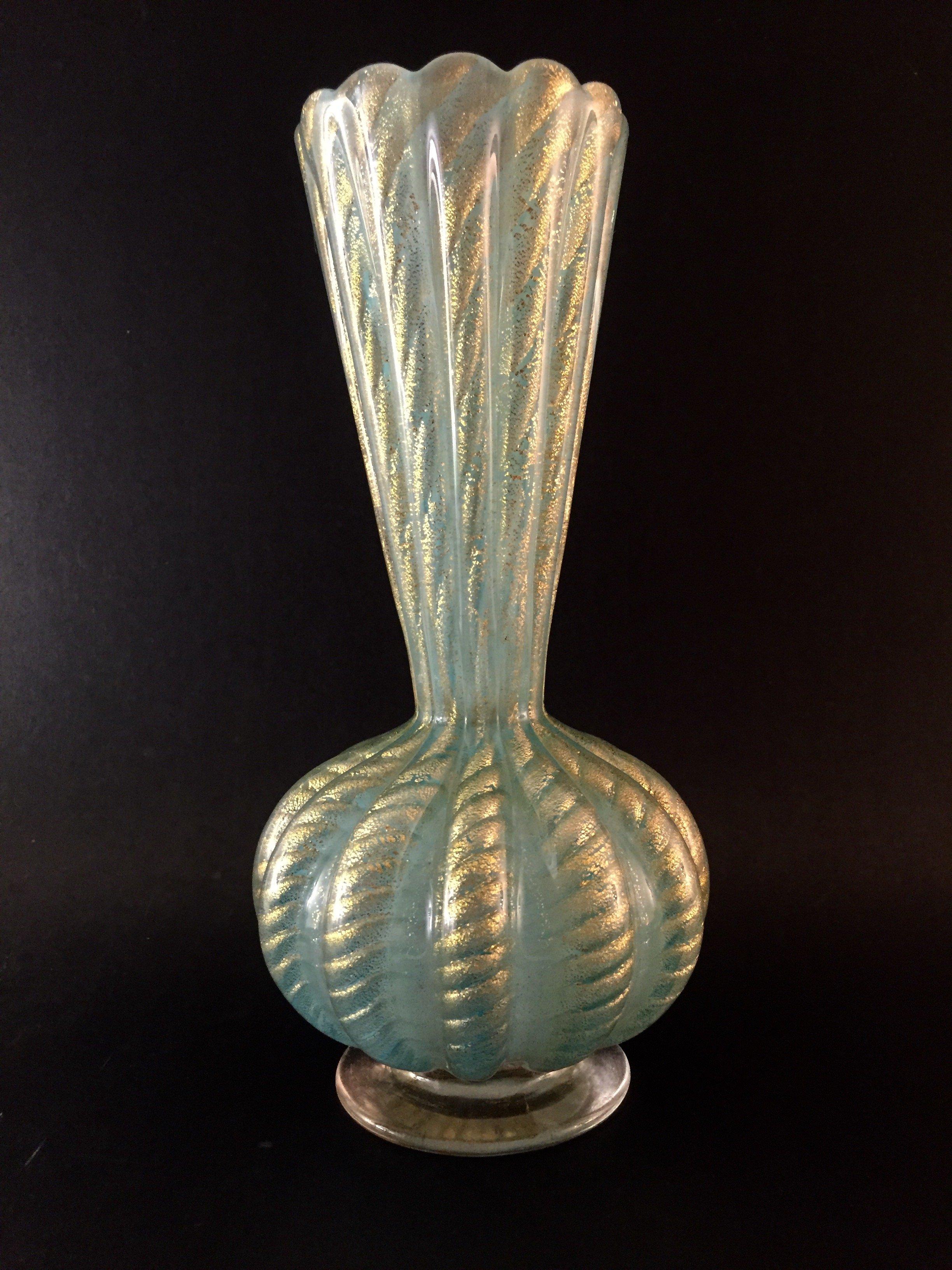 This exquisite 1950s Barovier & Toso vase features an elegant ribbed neck and body in delicate powder blue with swirling gold inclusions. The dazzling gold dust in the ribs gives it stunning definition and presence and at nine and a quarter inches