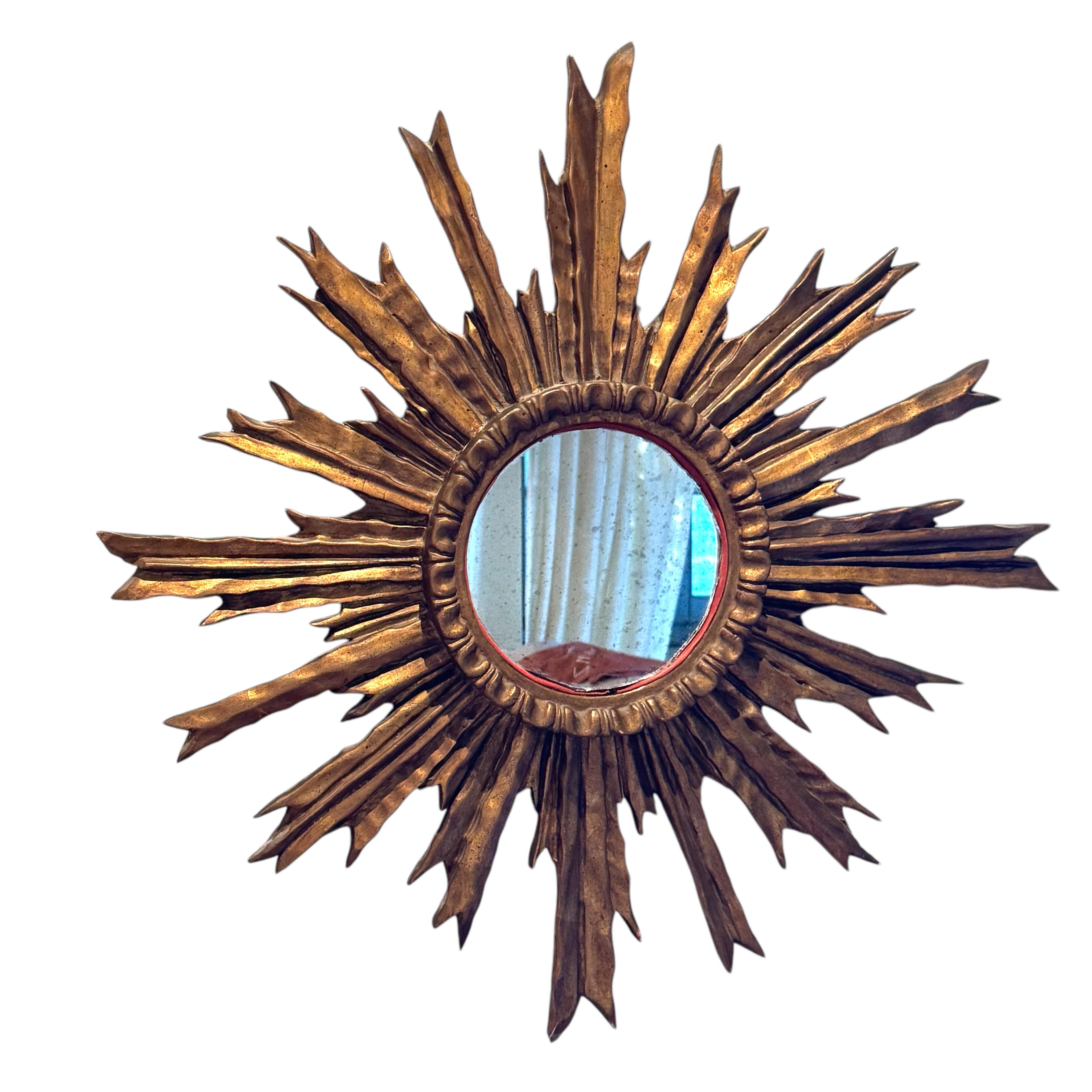 Ein schöner flacher Spiegel mit Starburst-Sonnenschliff. Hergestellt aus vergoldetem Holz. Es misst ca. 26,75
