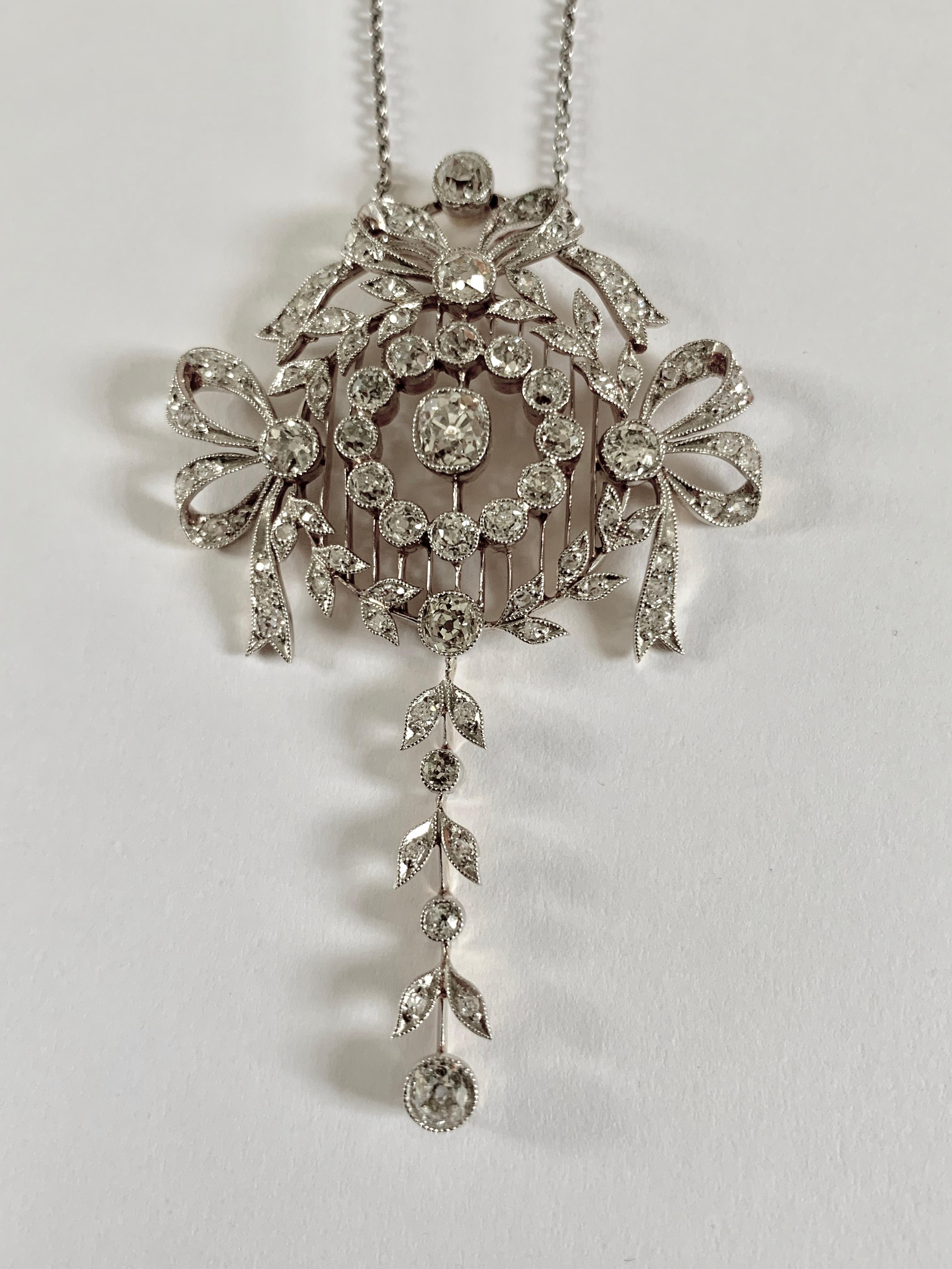Un ciondolo di platino e oro giallo con diamanti di qualità straordinaria, in tipico stile Belle Époque, la cui intricatezza è davvero notevole. Un fiocco mozzafiato raffigura  e motivi a ghirlanda tipici di questo periodo. Incastonato con un