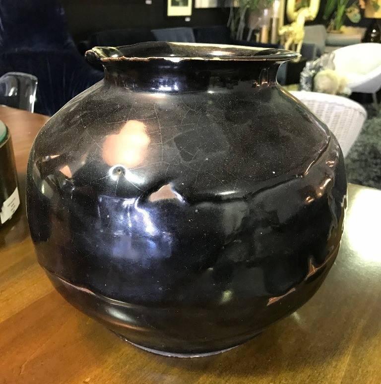 Clearly, some beautiful work went into this piece. The black crackle glaze radiates. The hand thrown earthenware pot, which is heavy and substantial, is signed and dated (