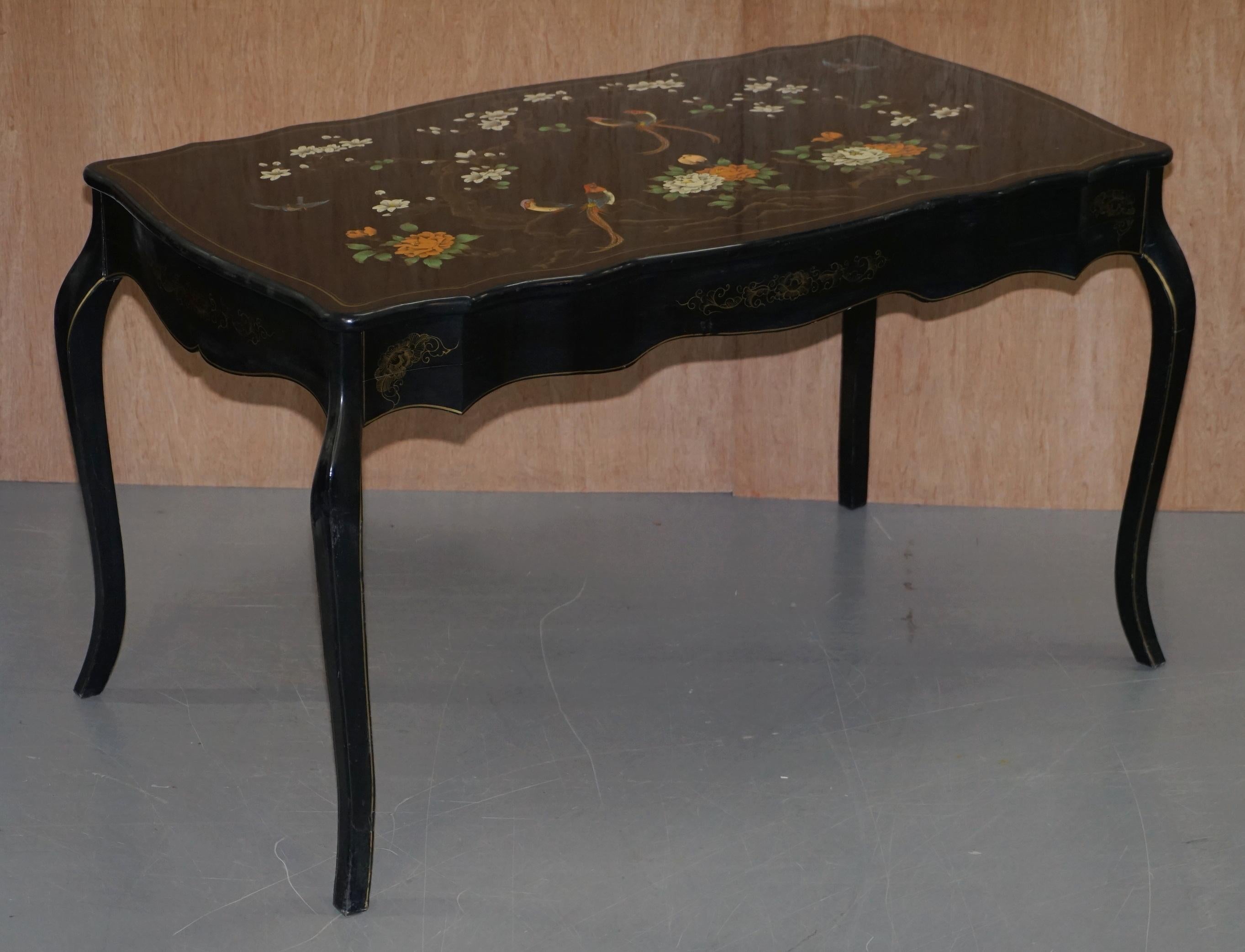 Estamos encantados de ofrecer a la venta esta preciosa mesa de escritorio vintage lacada en negro y pintada a mano con policromía con pájaros y flores 

Una pieza decorativa y de muy buen aspecto, realizada en estilo chino Chinoiserie. Los pájaros