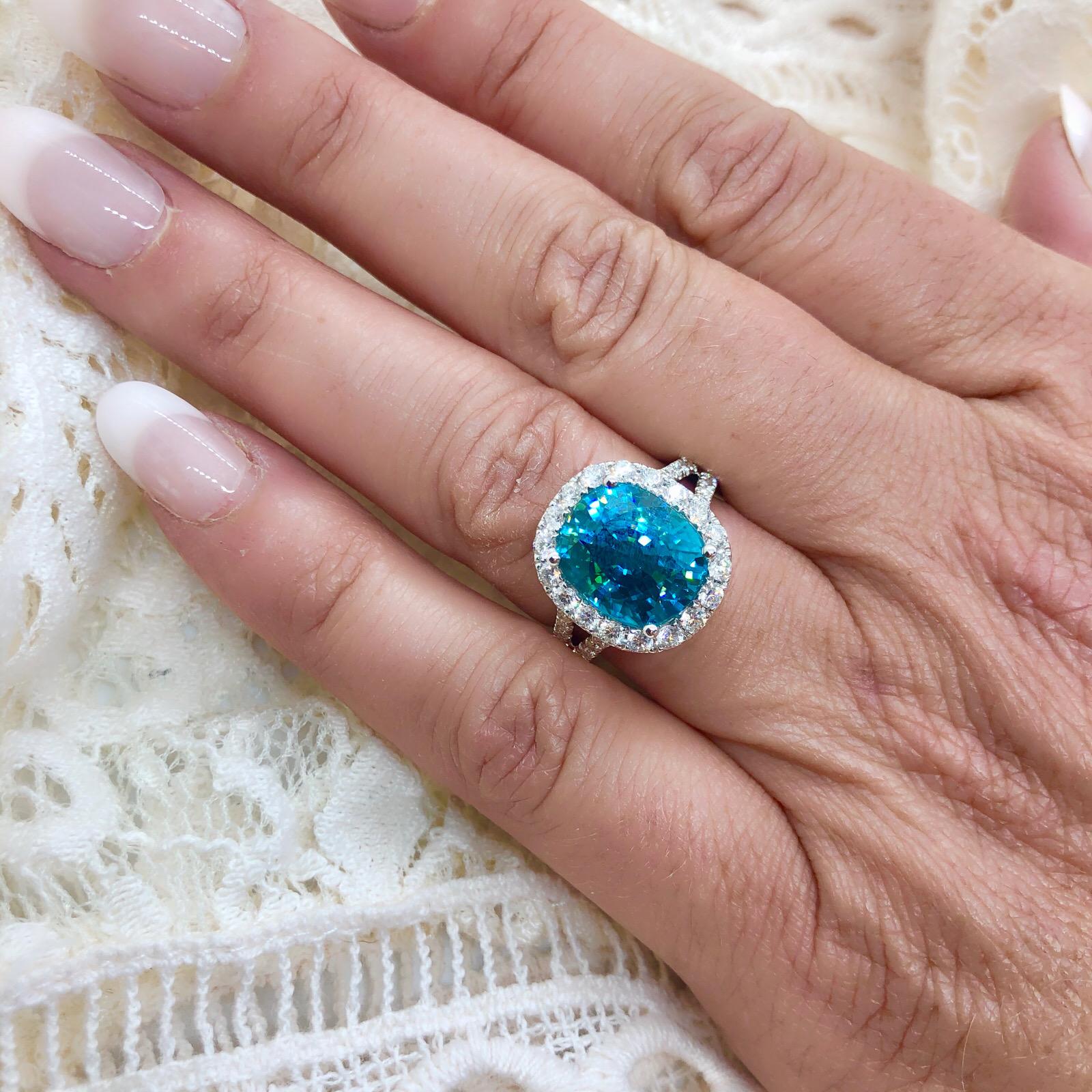 A blue like no other, this cushion-cut blue zircon is vibrant and eye-catching! Weighing an impressive 10.20 carats, it is set in an 18k white gold ring encrusted with 46 round brilliant-cut diamonds, for a total weight of 1.00 carats. The ring