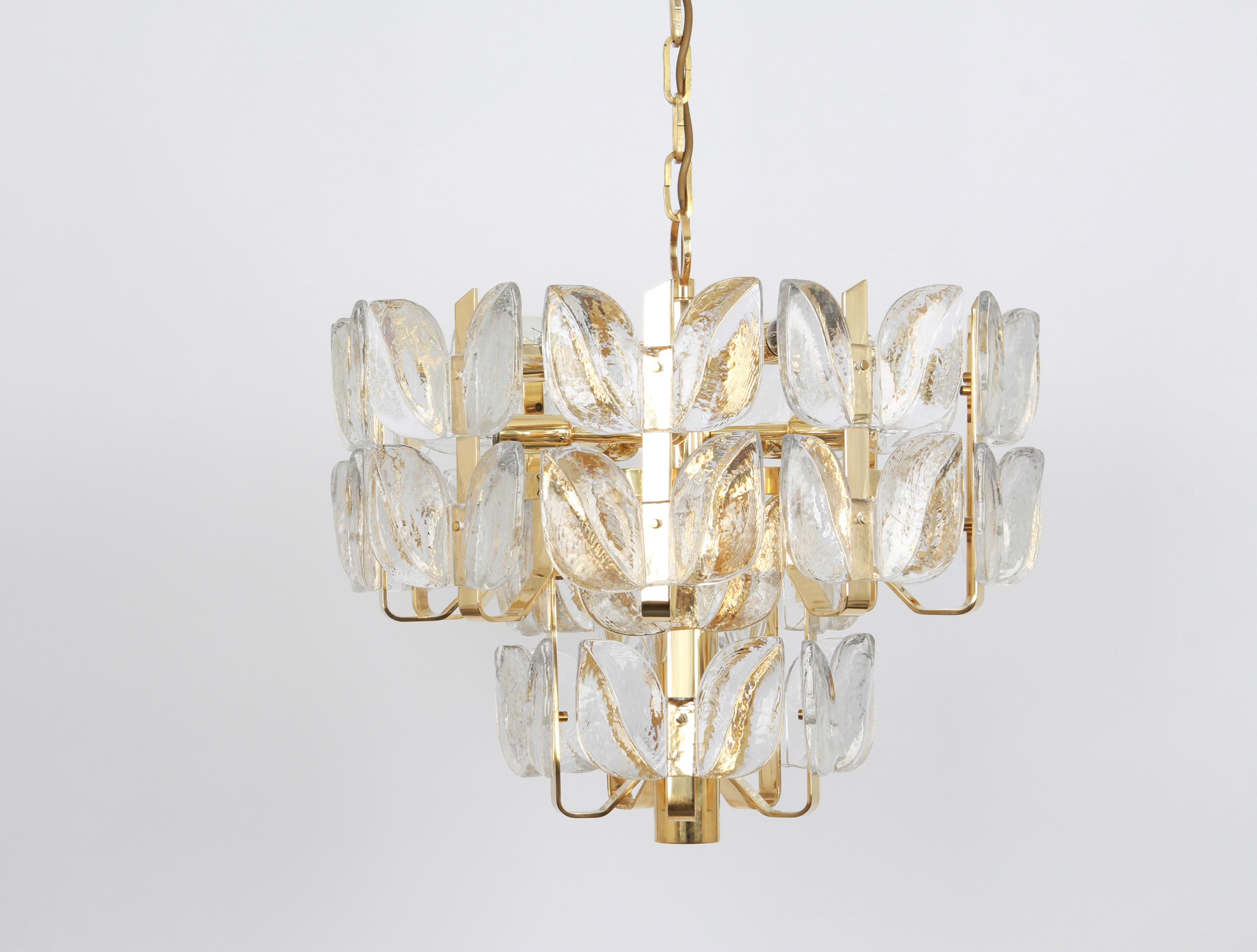 Wonderful gilt brass chandelier made by Kalmar (Serie: Florida), Austria, manufactured, circa 1970-1979.
Great structure gathering many structured glasses in leaves form, beautifully refracting the light very high quality.

High quality and in