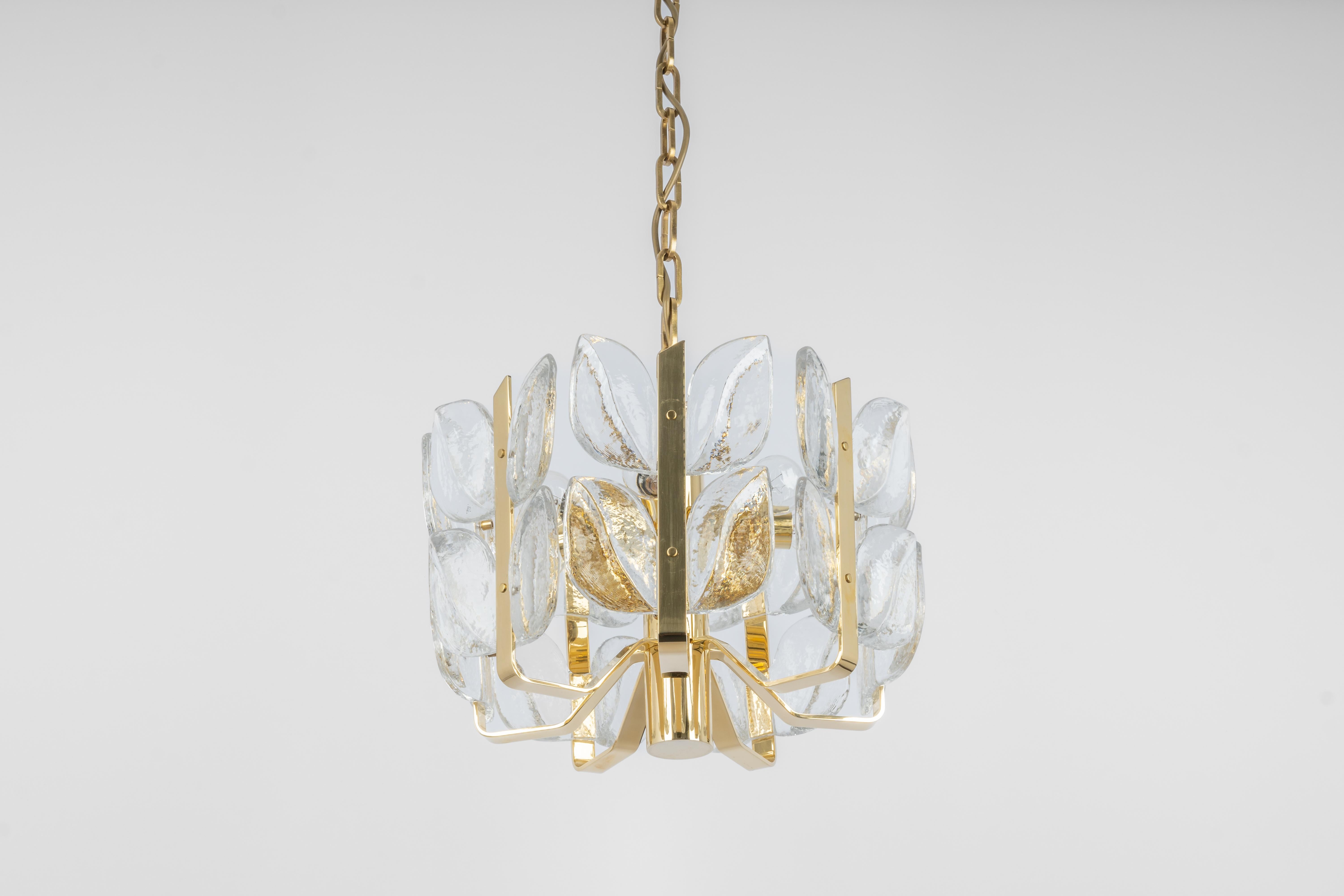 Wonderful gilt brass chandelier made by Kalmar (Serie: Florida), Austria, manufactured, circa 1970-1979.
Great structure gathering many structured glasses in leaves form, beautifully refracting the light very high quality.

High quality and in very