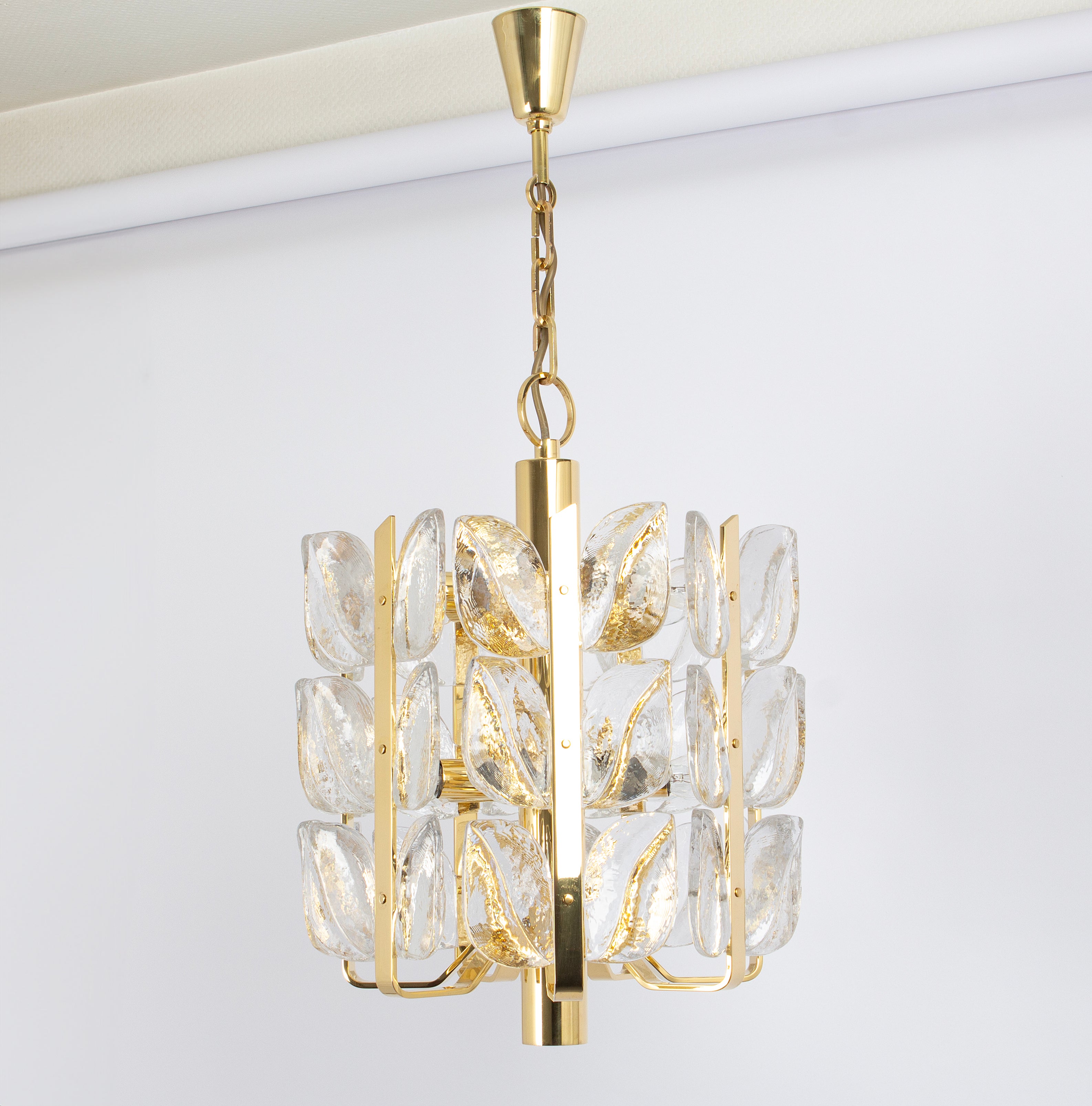 Wonderful gilt brass chandelier made by Kalmar (Serie: Florida), Austria, manufactured, circa 1970-1979.
Great structure gathering many structured glasses in leaves form, beautifully refracting the light very high quality.

High quality and in very