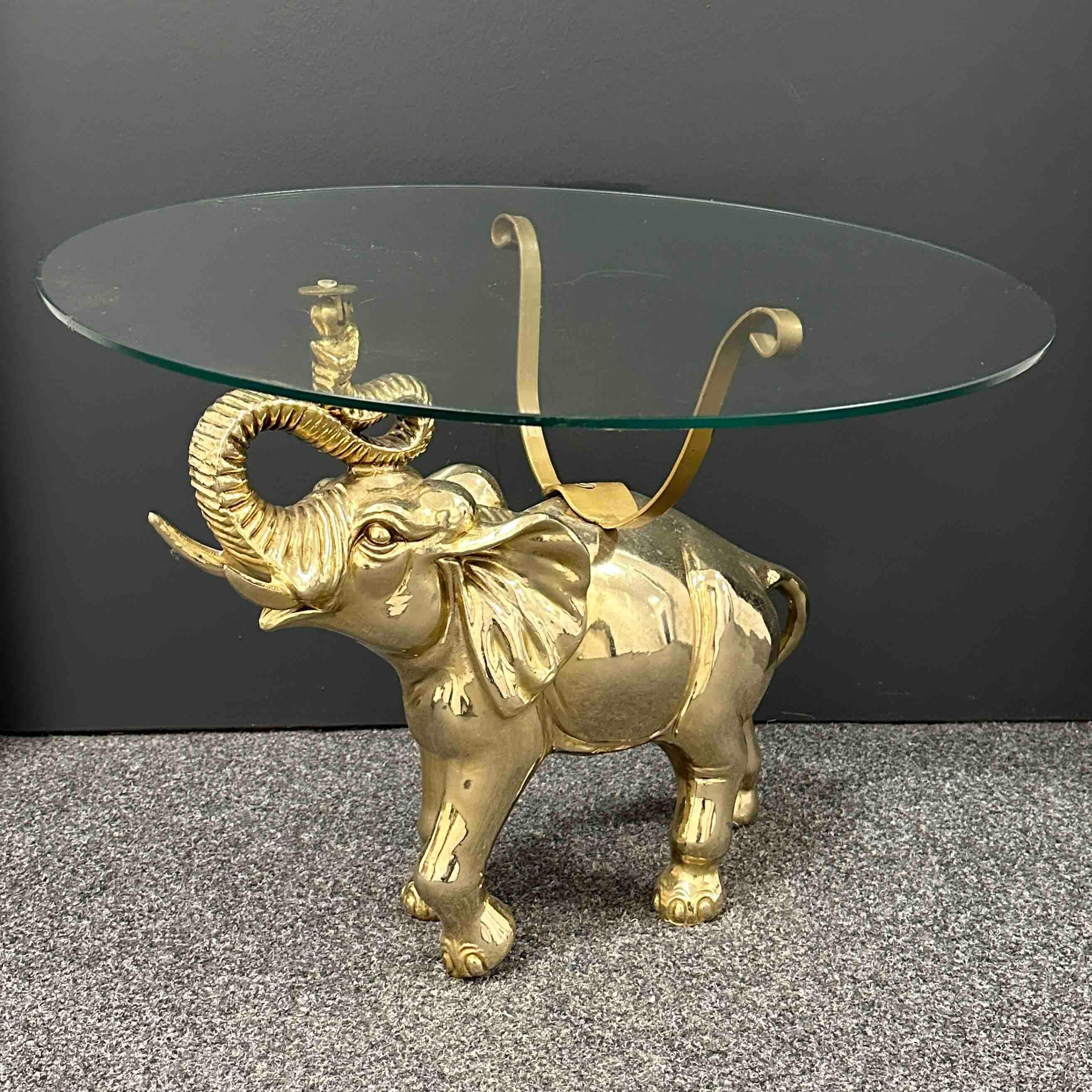 Offered is this beautiful Hollywood Regency figural Elephant side, end or coffee table. The heavy brass elephant sculpture is in beautiful condition. The Glass top has a diameter of 22 inches. The elephant itself is approx. 16.75