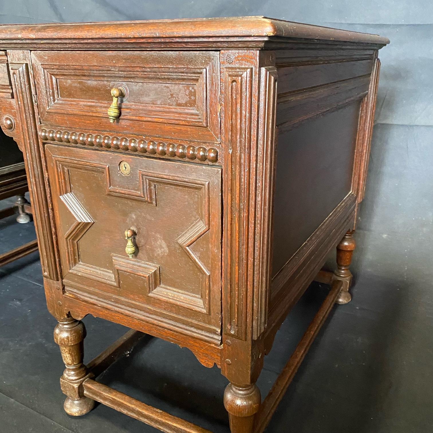 Fine and impressive early 20th century oak writing table or desk having beautiful details and plenty of storage. Details on both sides allows placement in the middle of a room. Very well done dovetailed drawers and reeded columned corners.