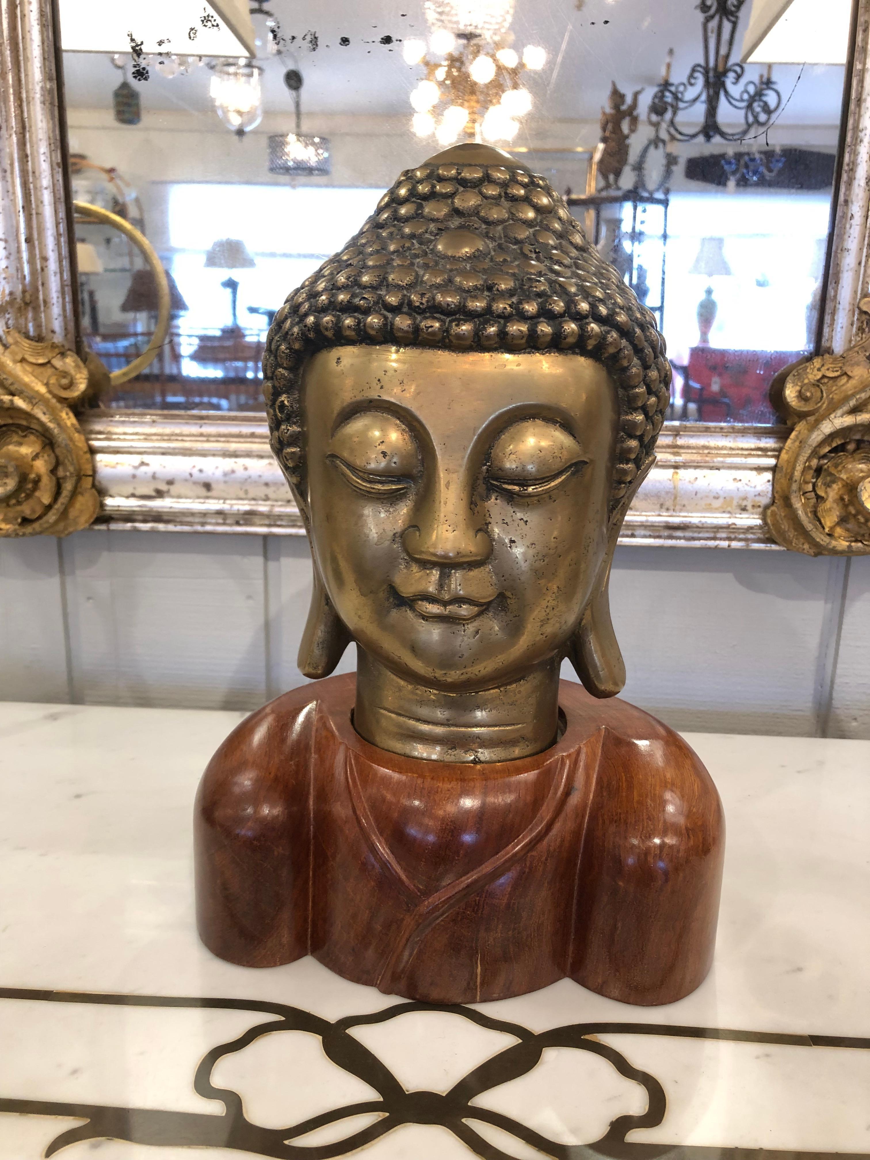 Striking Buddha head having meticulously detailed bronze bust and beautifully grained wooden base.