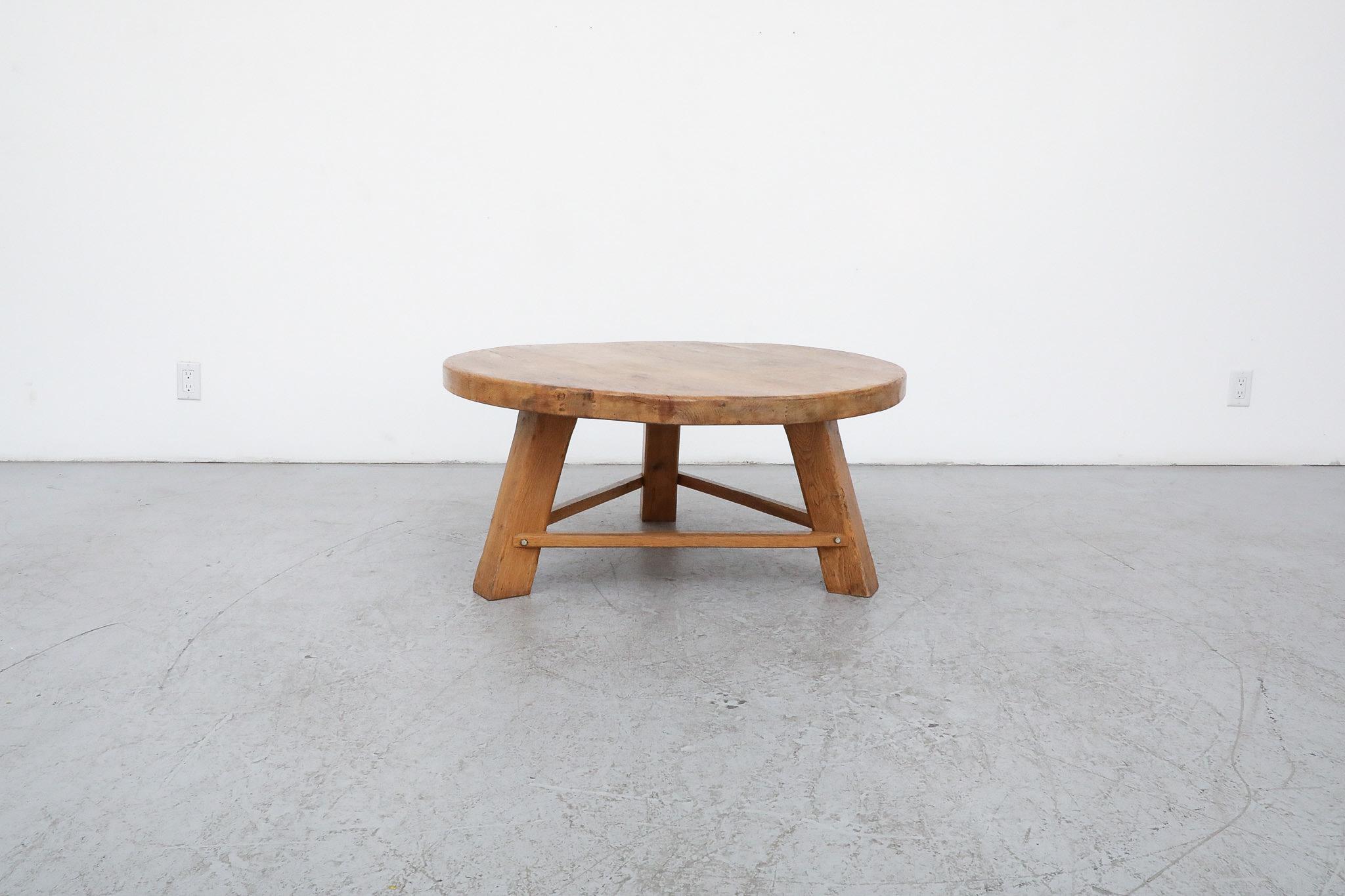 This beautiful, Mid-Century Chapo inspired Brutalist coffee table is made from solid oak with a round top, tripod legs and triangle support bar connecting the legs. In original condition with visible wear, including some natural cracking. Wear is
