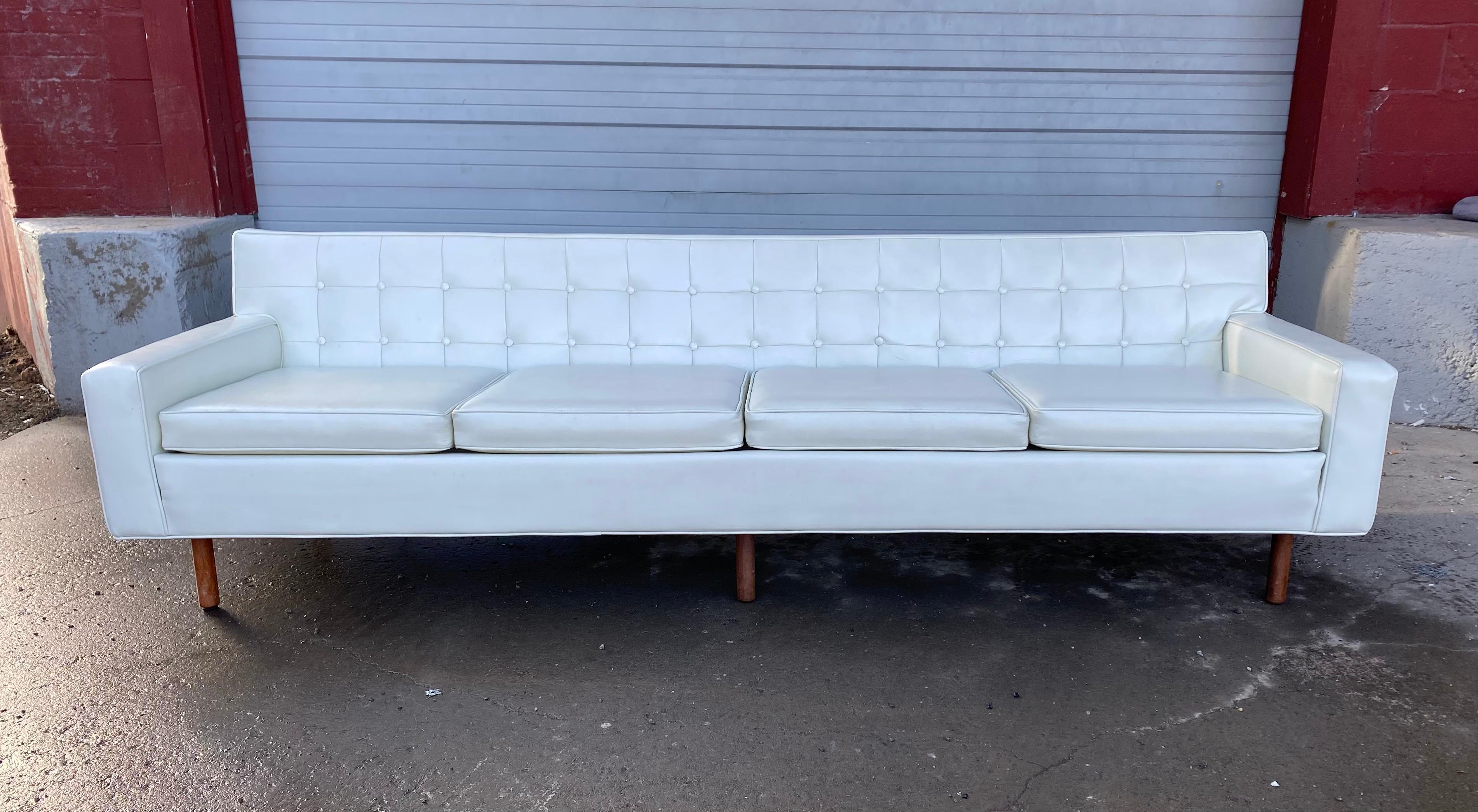 Stunning button tufted 4-seat sofa by Milo Baughman for Thayer Coggen. Classic Mid-Century Modern design, nice original condition, retains original white Naugahyde as well as original Thayer Coggen label, minor nik to back (see photo), hand delivery