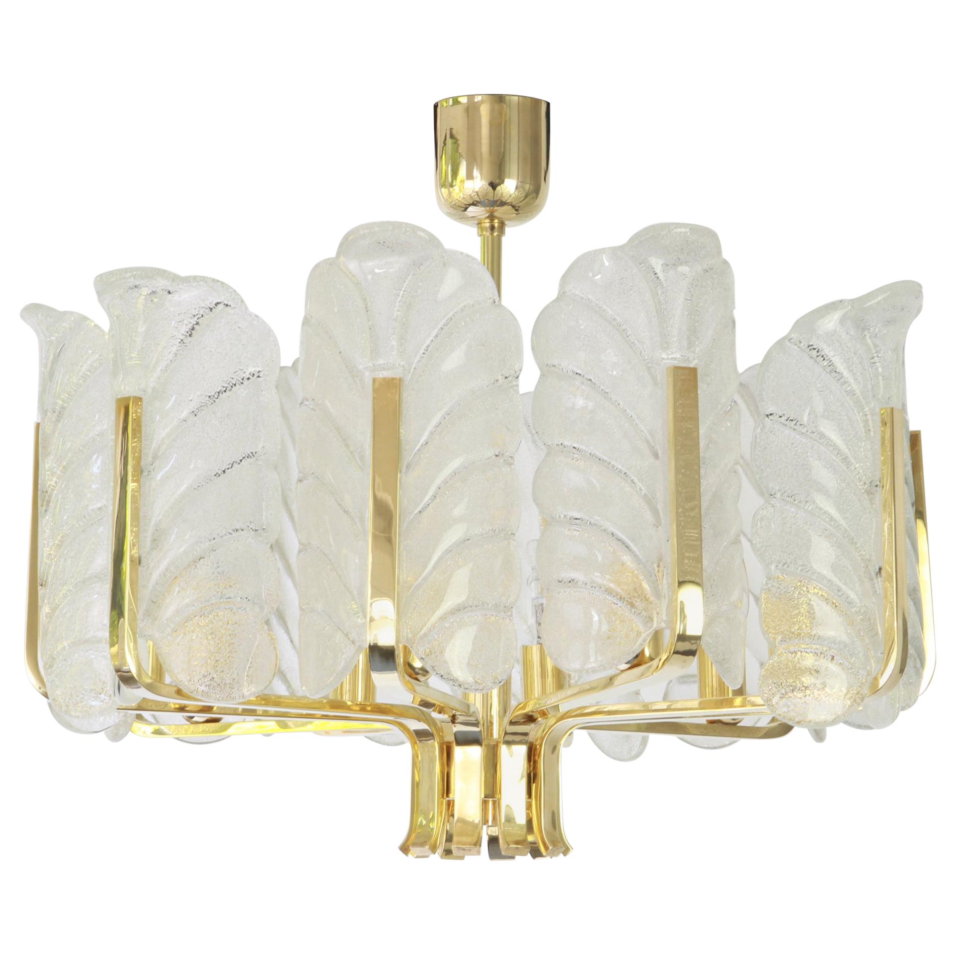 Very glamorous chandelier designed by Carl Fagerlund for Orrefors glass, Sweden, manufactured in midcentury, circa 1960-1969. The light features a polished brass frame with eight stunning Murano glass leaves which have a matte frosted relief on the