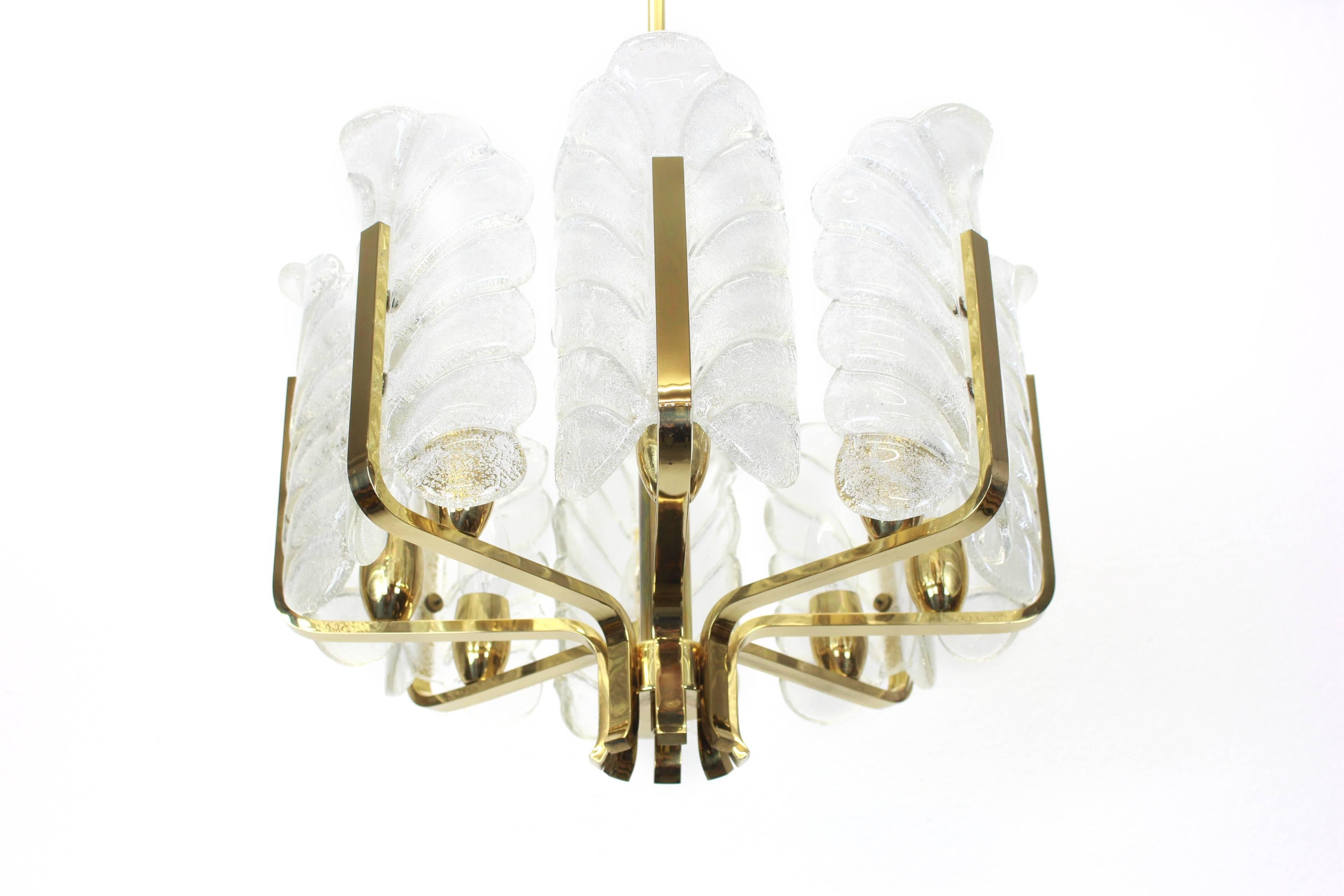 Very glamorous chandelier designed by Carl Fagerlund for Orrefors glass, Sweden, manufactured in midcentury, circa 1960-1969. The light features a polished brass frame with eight stunning Murano glass leaves which have a matte frosted relief on the