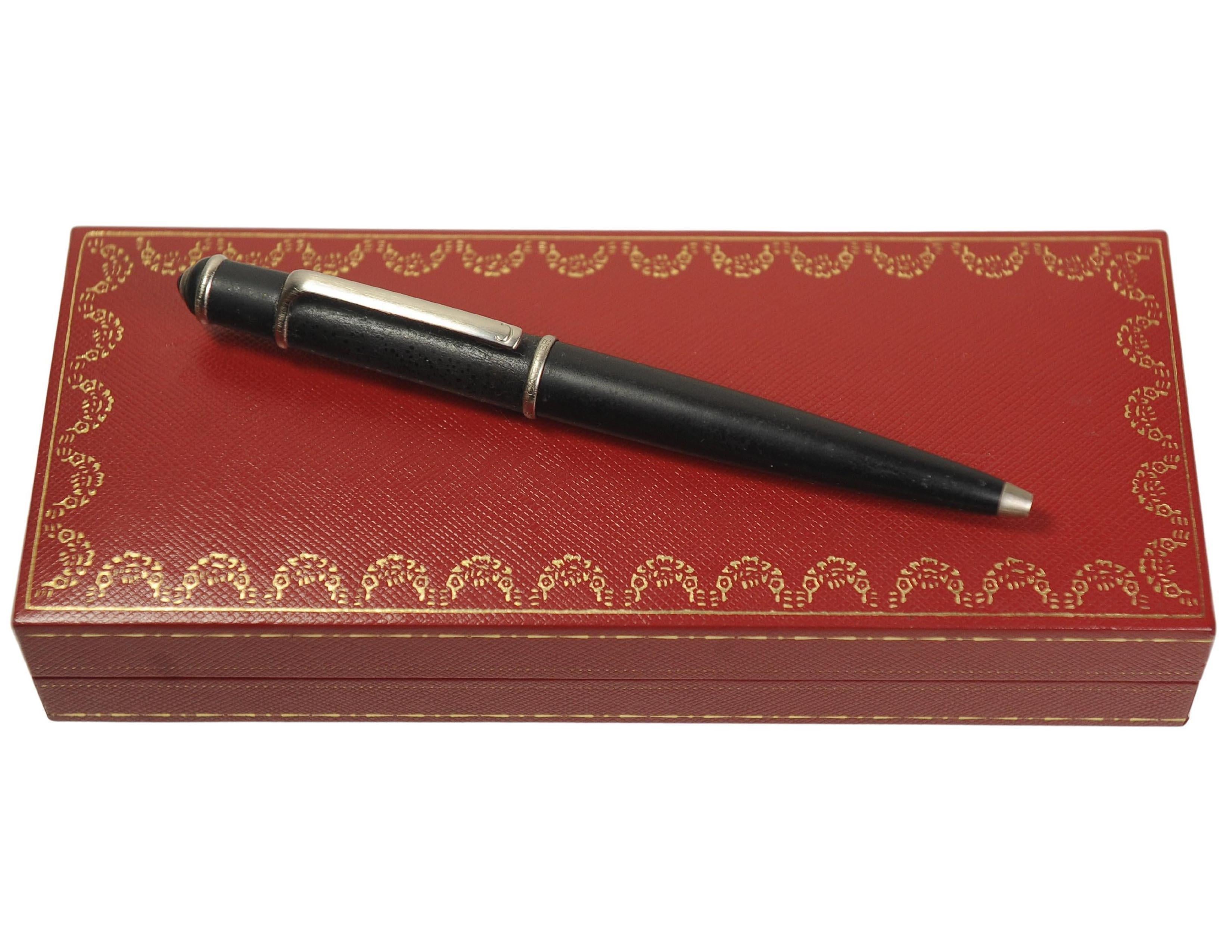 Ein eleganter Diabolo de Cartier Kugelschreiber aus schwarzem Komposit, mit Details aus Stahl und blauem Harz-Cabochon. 

Abmessung: 136,5 mm 

Hergestellt von Montblanc

Cartier Schreibgeräte werden von Cartier entworfen und von Montblanc