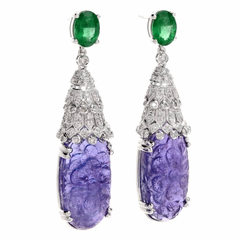 These Estate Dec style earrings are rendered in 18-karat white gold and incorporate a pair of oval-shape ornately carved on both facets, tanzanite gems  of enchanting medium violet color, weighing together 33.66 carats in total ,  secured by 4
