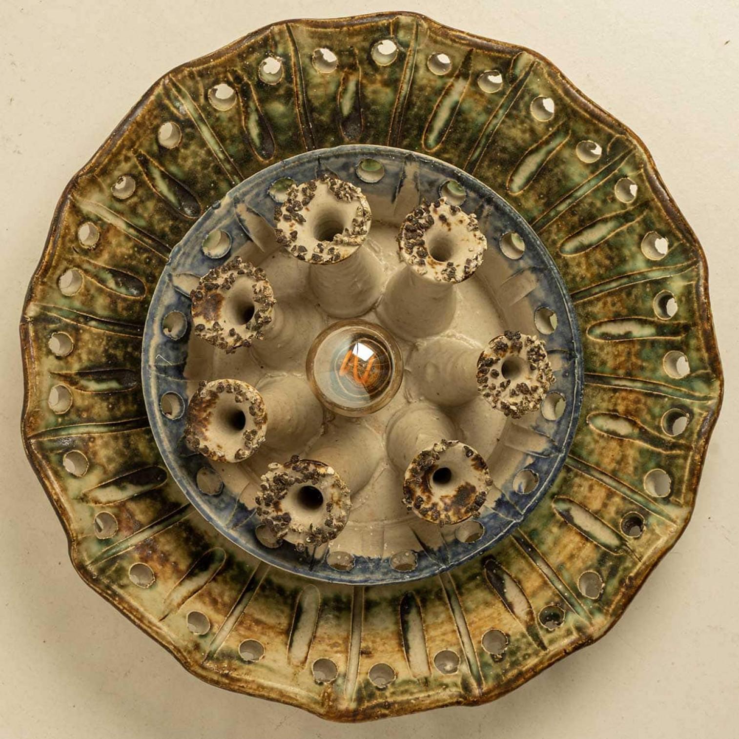 Spectacular circular ceramic wall light, with beautiful accents. Manufactured in Denmark in the 1970s. In excellent condition, in the style of Axella. A beautiful wall light that complements many interiors.

Cleaned, well-wired and ready to use.
The