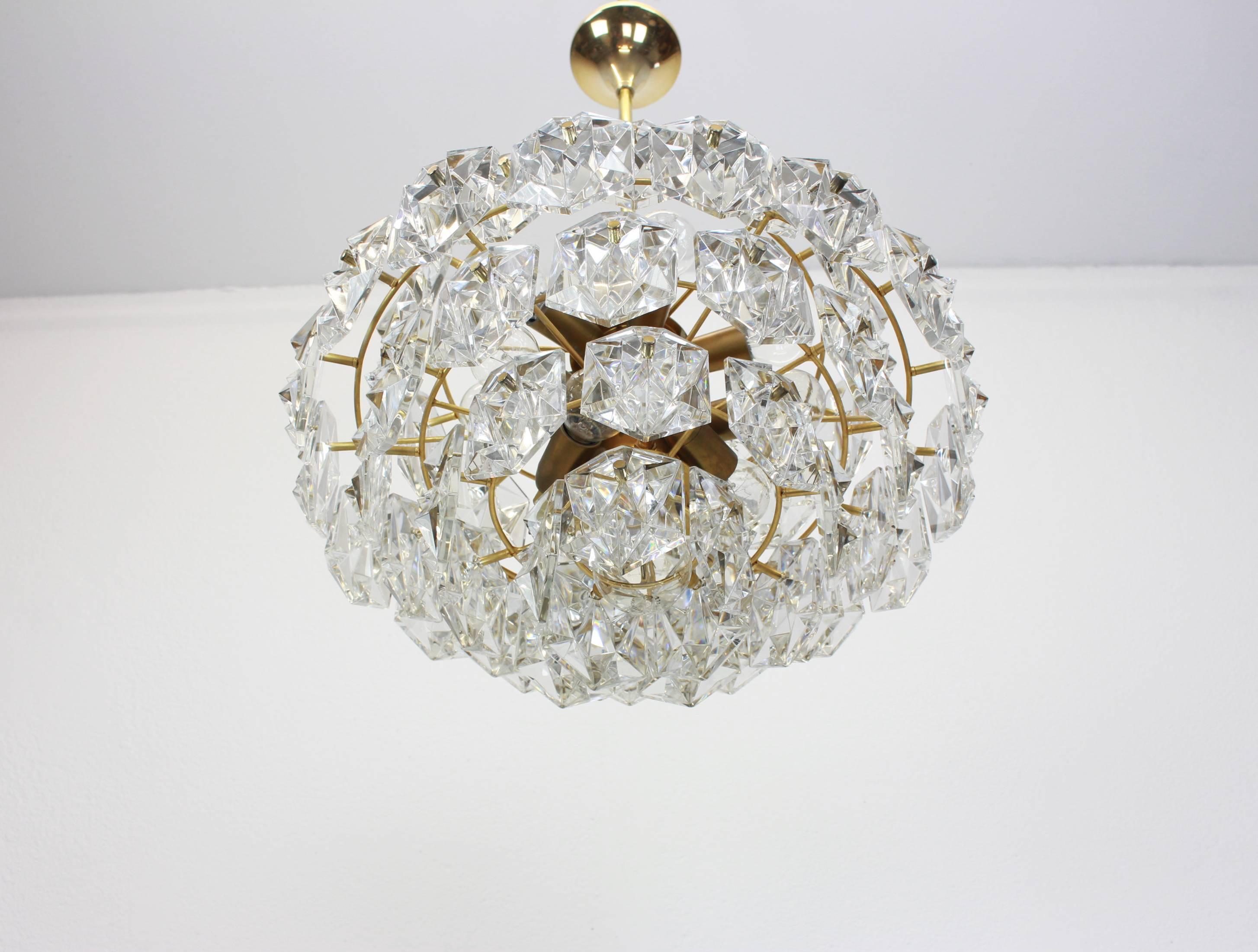 A stunning five-tier chandelier by Kinkeldey, Germany, manufactured in circa 1960-1969. A handmade and high-quality piece. The ceiling fixture and the frame are made of brass and have five rings with lots of faceted crystal glass elements.

High