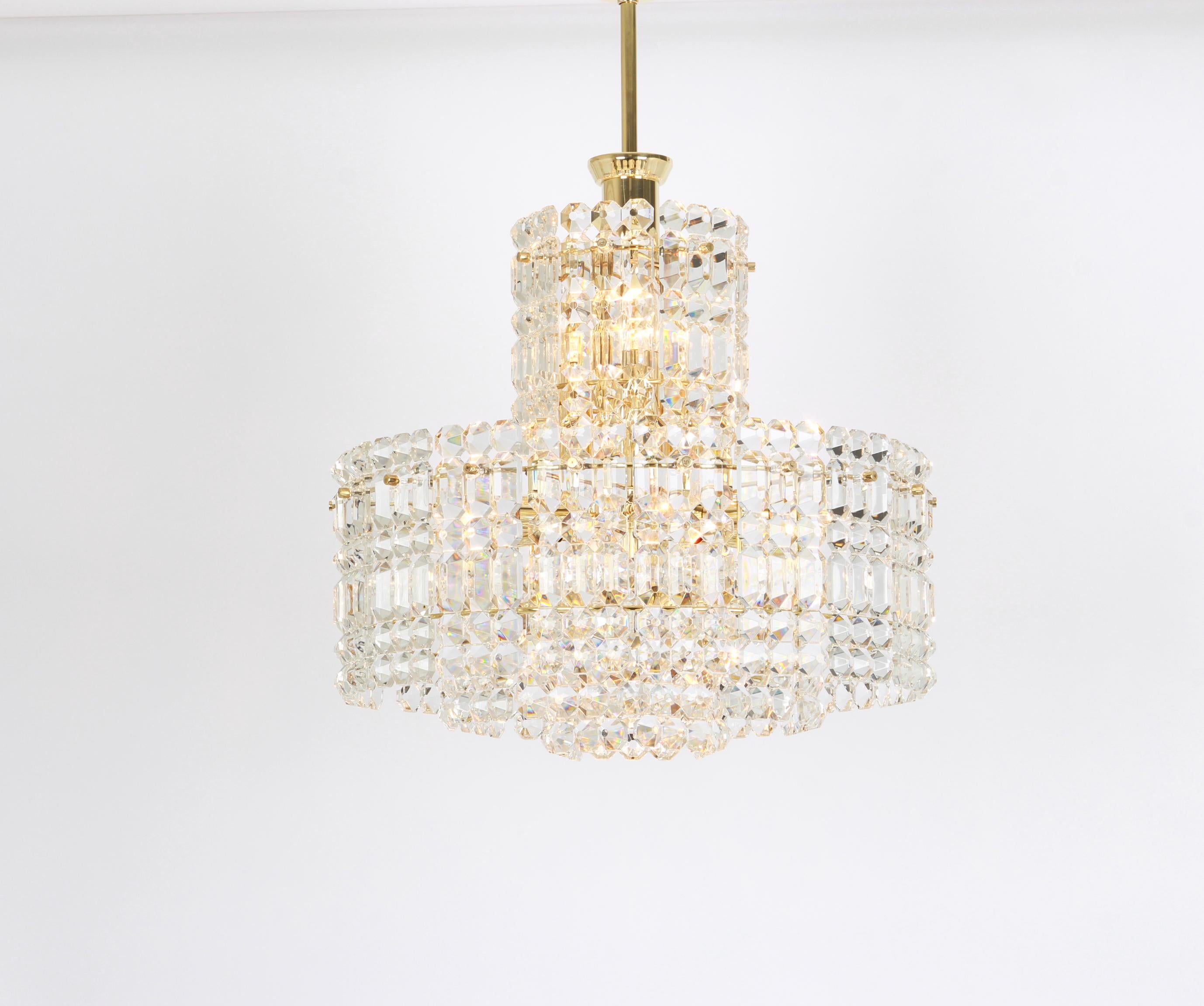 A stunning four-tier chandelier by Kinkeldey, Germany, manufactured in circa 1960-1969. A handmade and high-quality piece. The ceiling fixture and the frame are made of brass and have four rings with lots of faceted crystal glass elements.

High