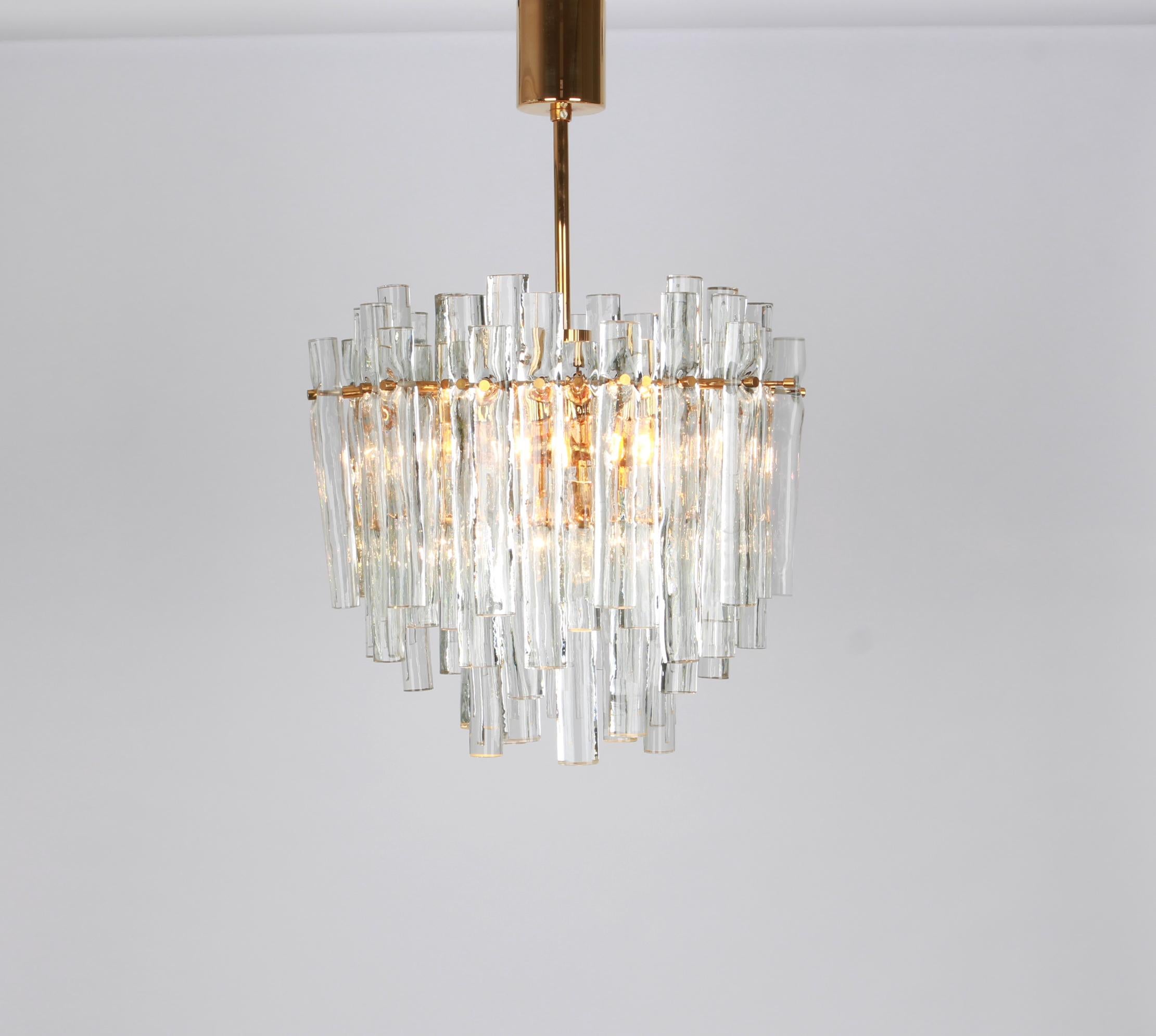 A stunning chandelier by Kinkeldey, Germany, manufactured in circa 1970-1979. A handmade and high quality piece. The ceiling fixture and the frame are made of brass and a ring with lots of facetted crystal glass elements.
Modell: Cascade
Sockets: