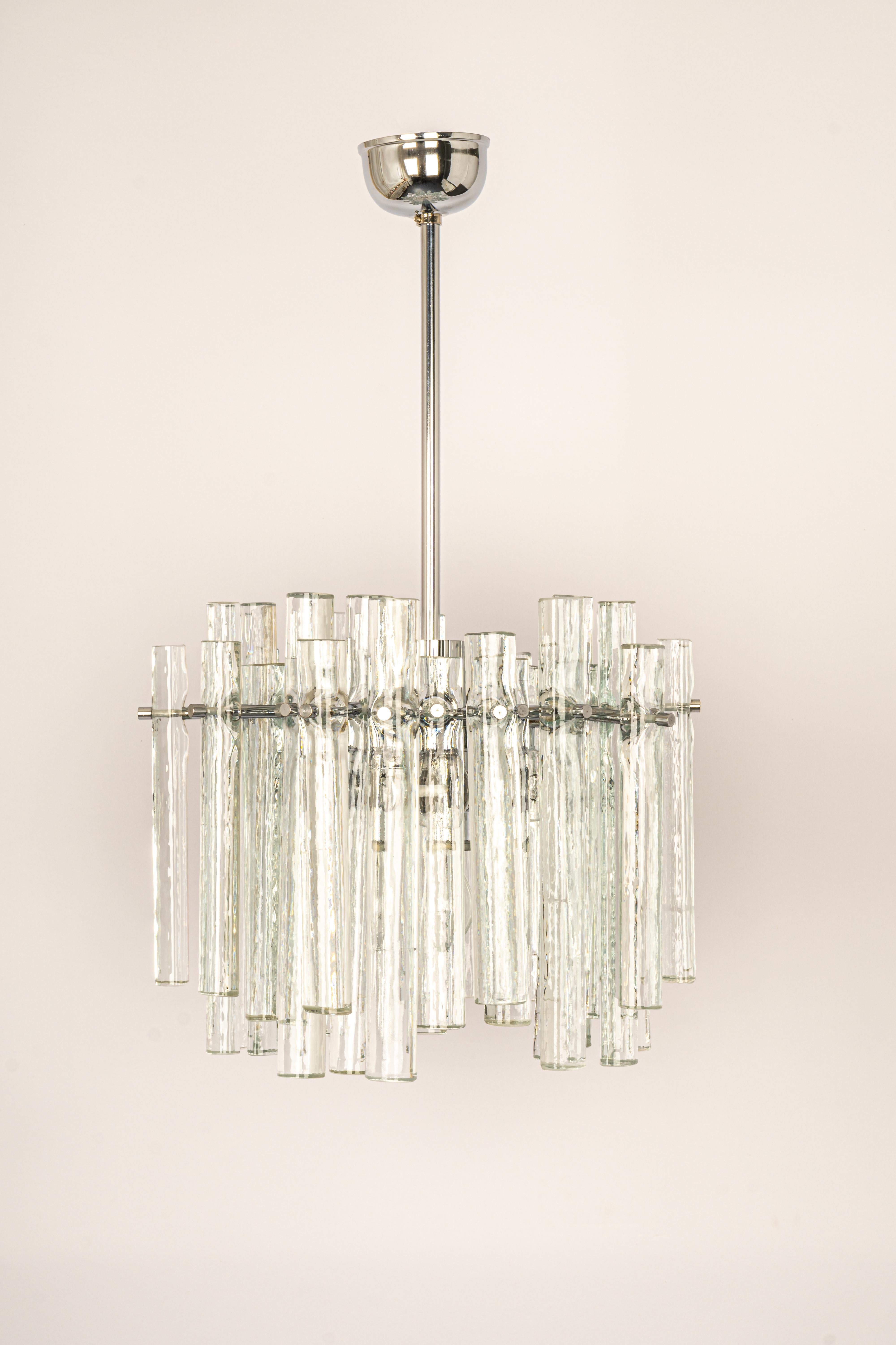 A stunning chandelier by Kinkeldey, Germany, manufactured in circa 1970-1979. A handmade and high-quality piece. The ceiling fixture and the frame are made of Chrome and a ring with lots of facetted crystal glass elements.
Modell: Cascade
Sockets: