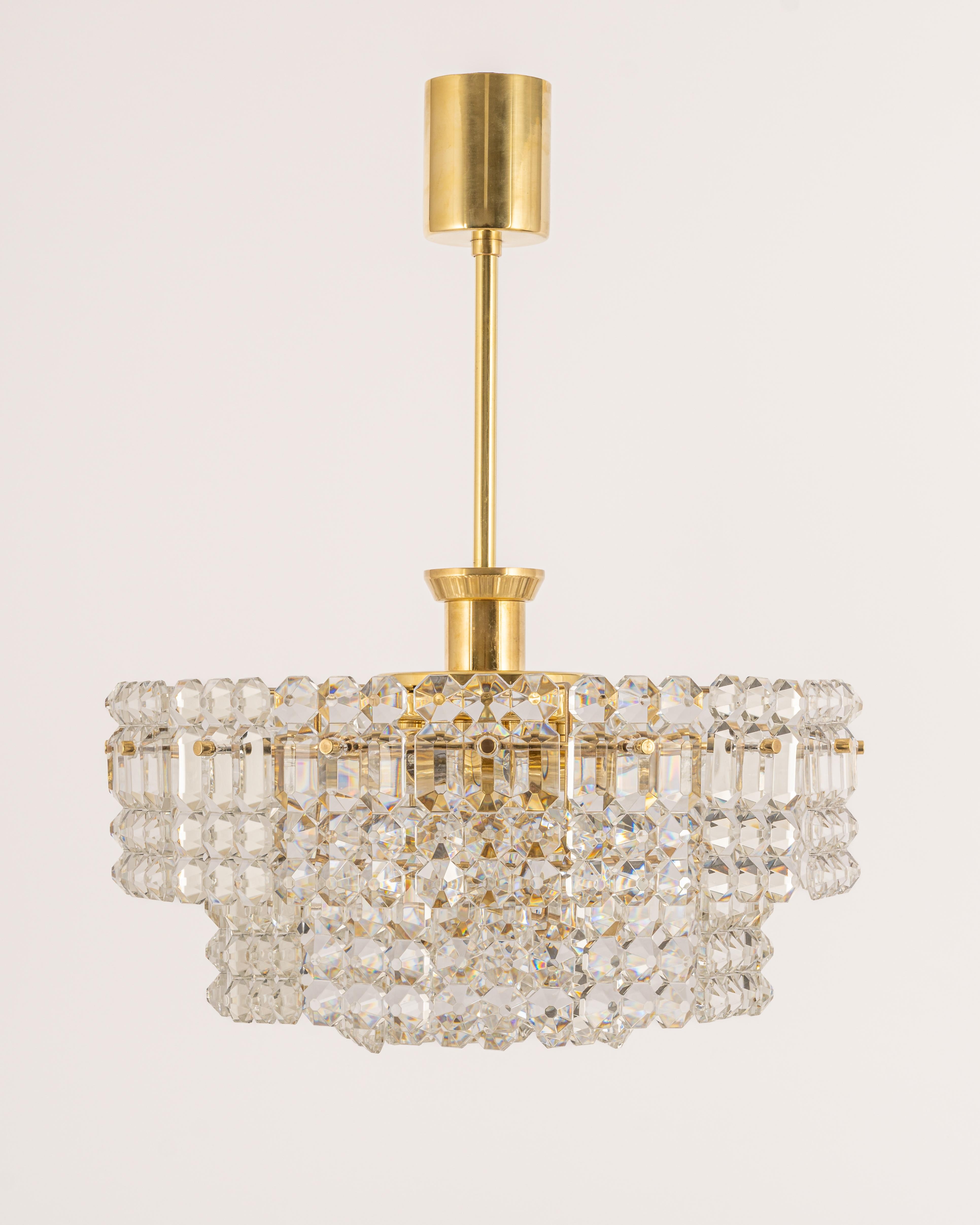 A stunning chandelier by Kinkeldey, Germany, manufactured circa 1970-1979. A handmade and high-quality piece. The ceiling fixture and the frame are made of brass and have 3 rings with lots of facetted crystal glass elements.

High quality and in