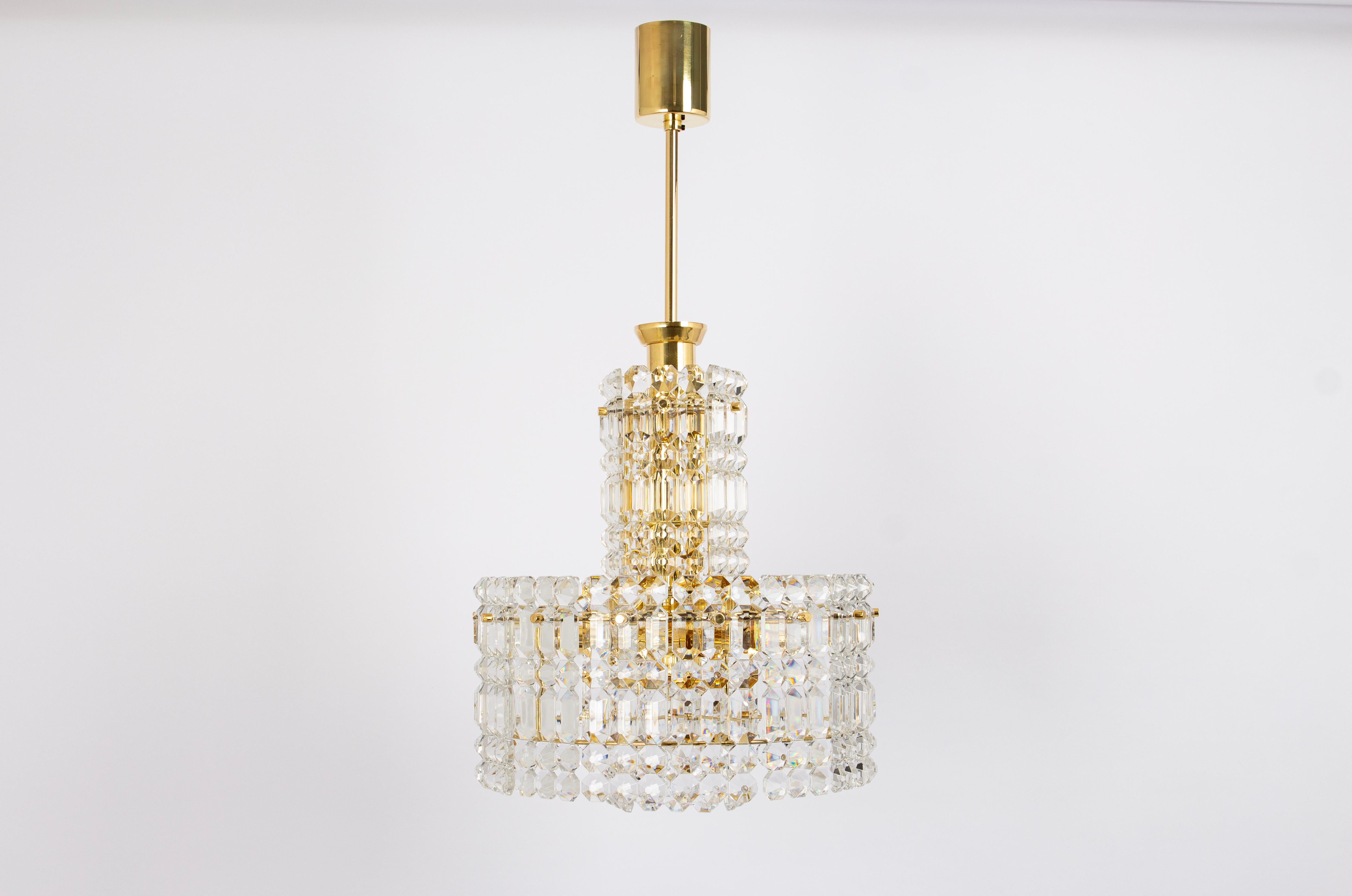 A stunning chandelier by Kinkeldey, Germany, manufactured circa 1970-1979. A handmade and high-quality piece. The ceiling fixture and the frame are made of brass and have 3 rings with lots of facetted crystal glass elements.

High quality and in