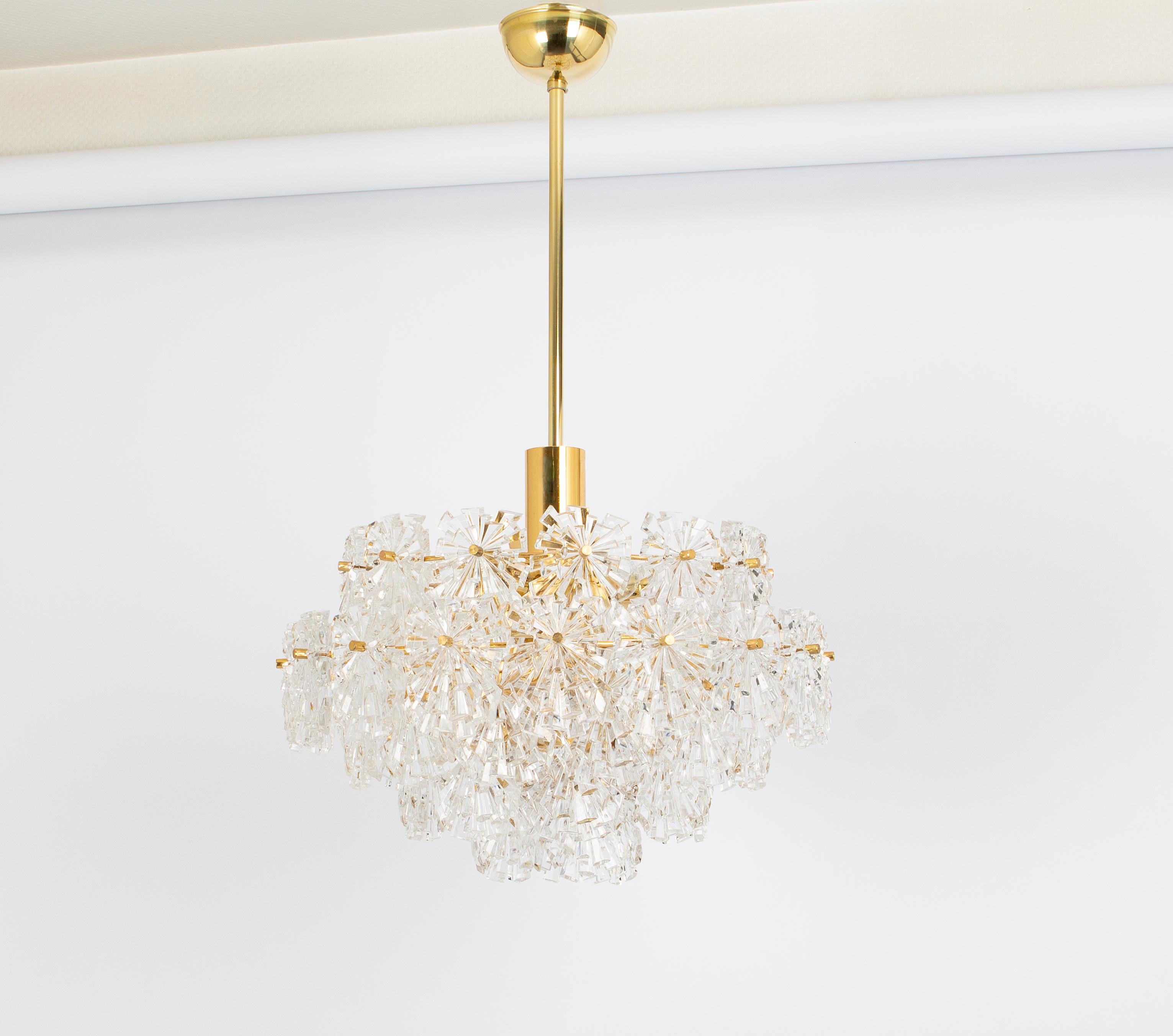 A stunning chandelier made by Ott International ( Kinkeldey ), Germany, manufactured in circa 1970-1979. A handmade and high-quality piece. The chandelier is made of brass and have rings with lots of facetted crystal glass elements.

Heavy quality