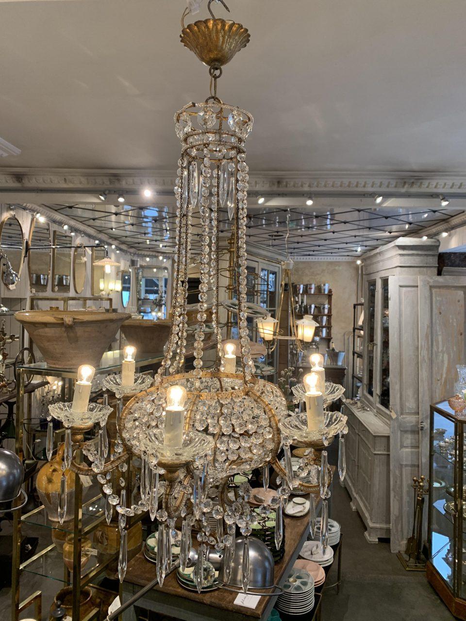 Exquisite and stately drop-shaped crystal chandelier /ceiling lamp. France, circa early 1900s.

Elegantly designed with a beautiful gilded iron frame, on which sit 6 small gilded wood light pipes with pale cuffs in clear glass.

Hundreds of