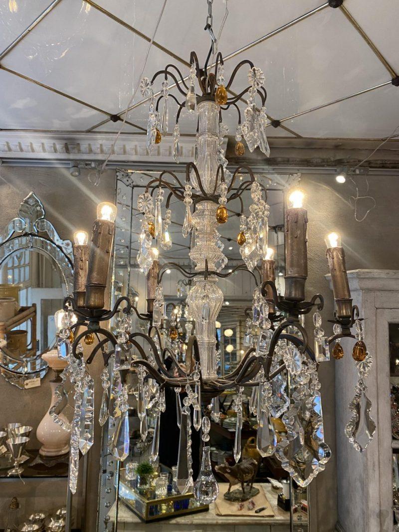 Stunning old chandelier from circa 1900s France, in burnished brass, and which is beautifully ornate with countless prisms.

True opulence of faceted prisms in various sizes, held in fine clear and amber tones that elegantly catch and reflect the