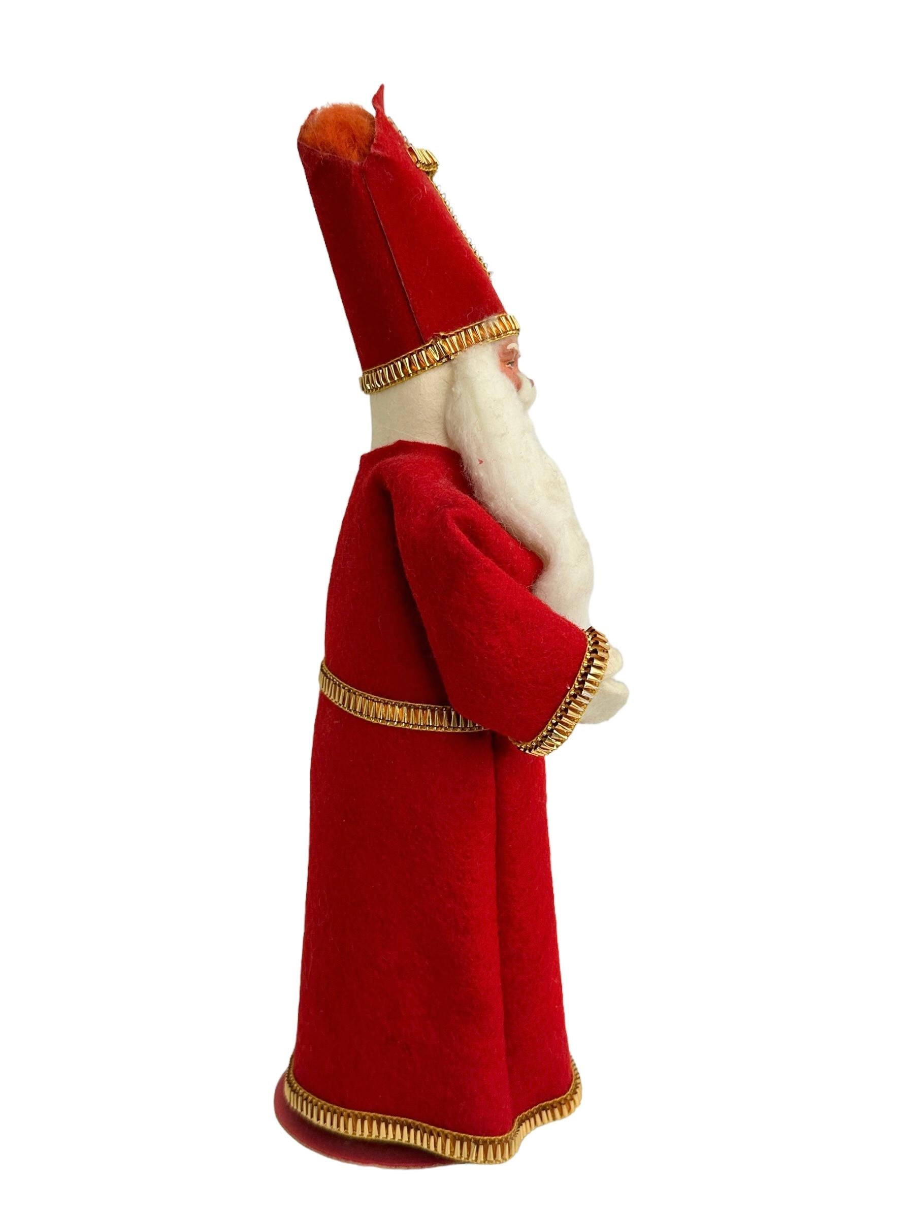 This vintage St.Nicholas, Santa Claus Christmas Figurine made of composition, cardboard, felting and Papermache was made in the 20th century and is a charming addition to any Christmas collection. This original period piece was made in Germany and