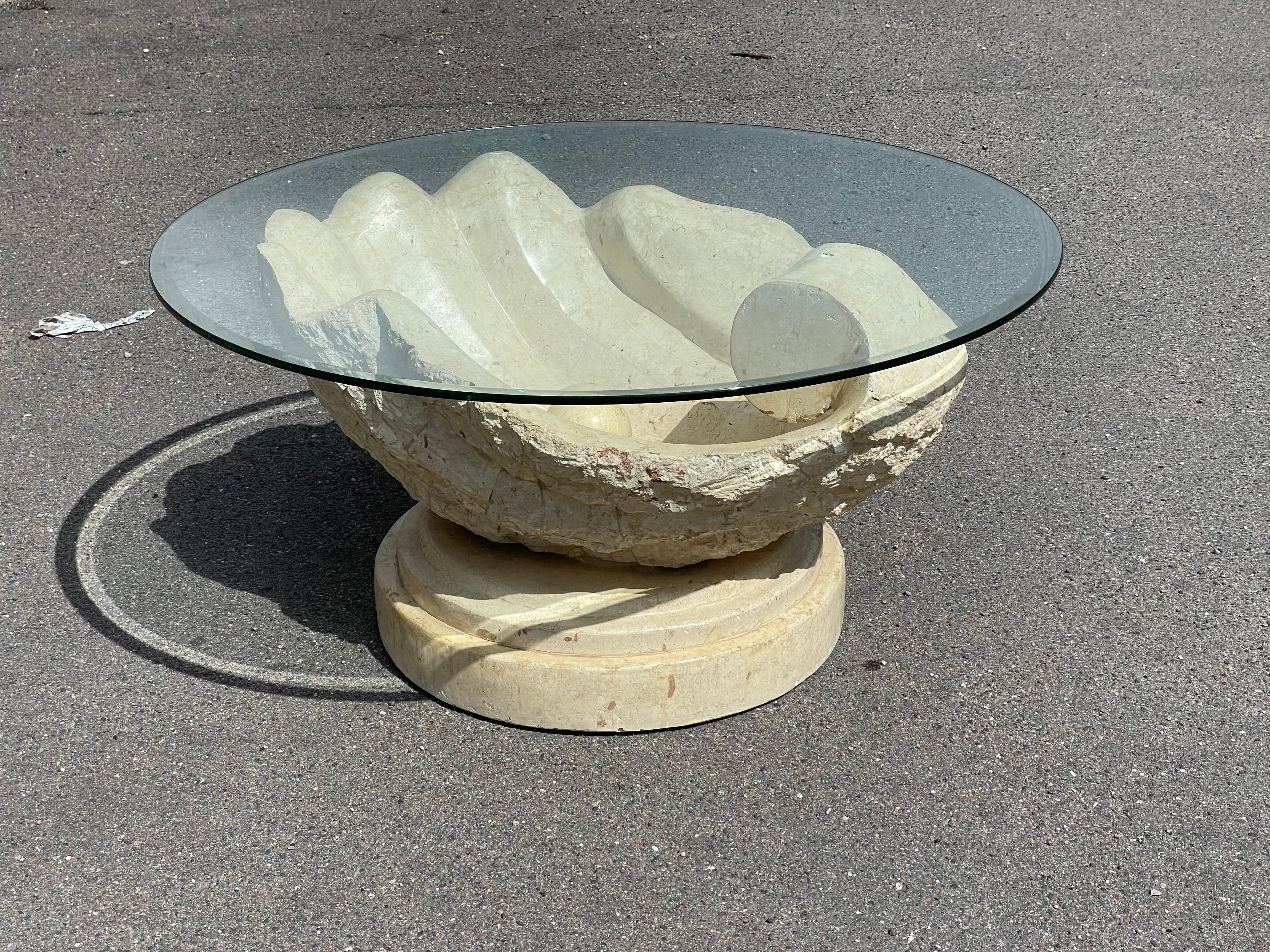 Step back in time with the Magnussen Ponte coffee table from the 1980s. Inspired by the elegance of an oyster with a hidden pearl, this masterpiece is crafted from exquisite Mactan stone. The round glass top, skillfully facet cut, adds a touch of