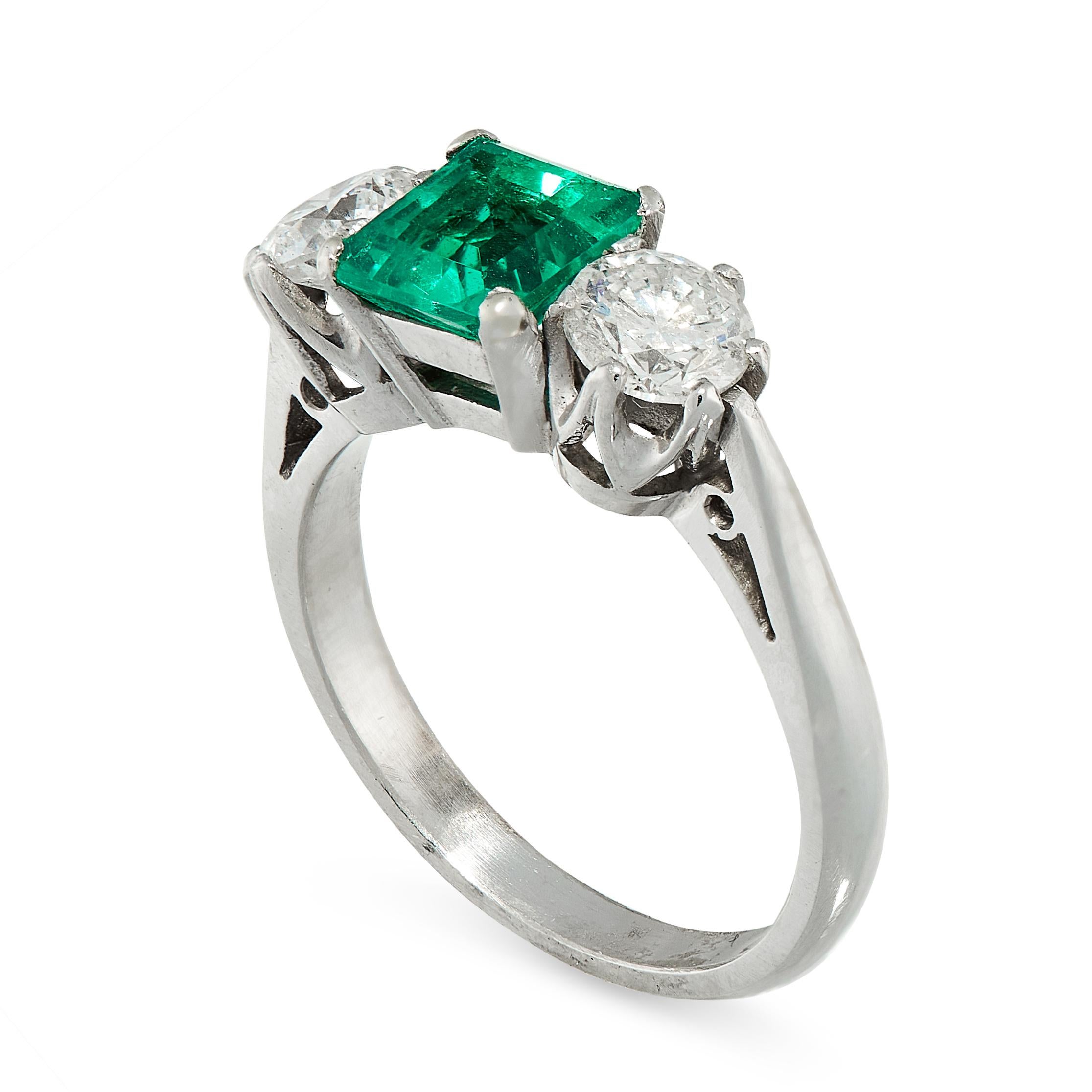 A stunning and classic ring that in the center is a square cut  1.1ct Columbian emerald set within platinum claws.  The emerald is a particularly good saturated green and contrasts well with the bright white diamonds. On either side are three