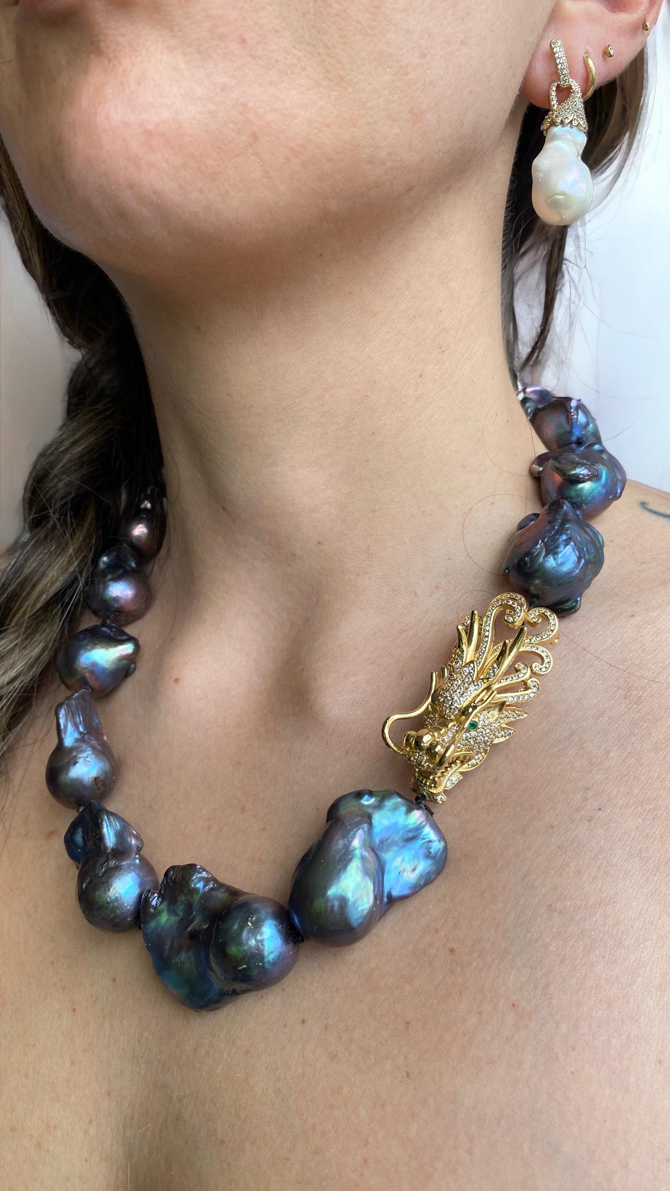This unique piece by Sebastian Jaramillo features stunning peacock toned cultured baroque pearls, delicately calibrated and feature a golden dragon head set in micro crystals and deep emerald colored eyes. This elegant yet edgy necklace and the deep