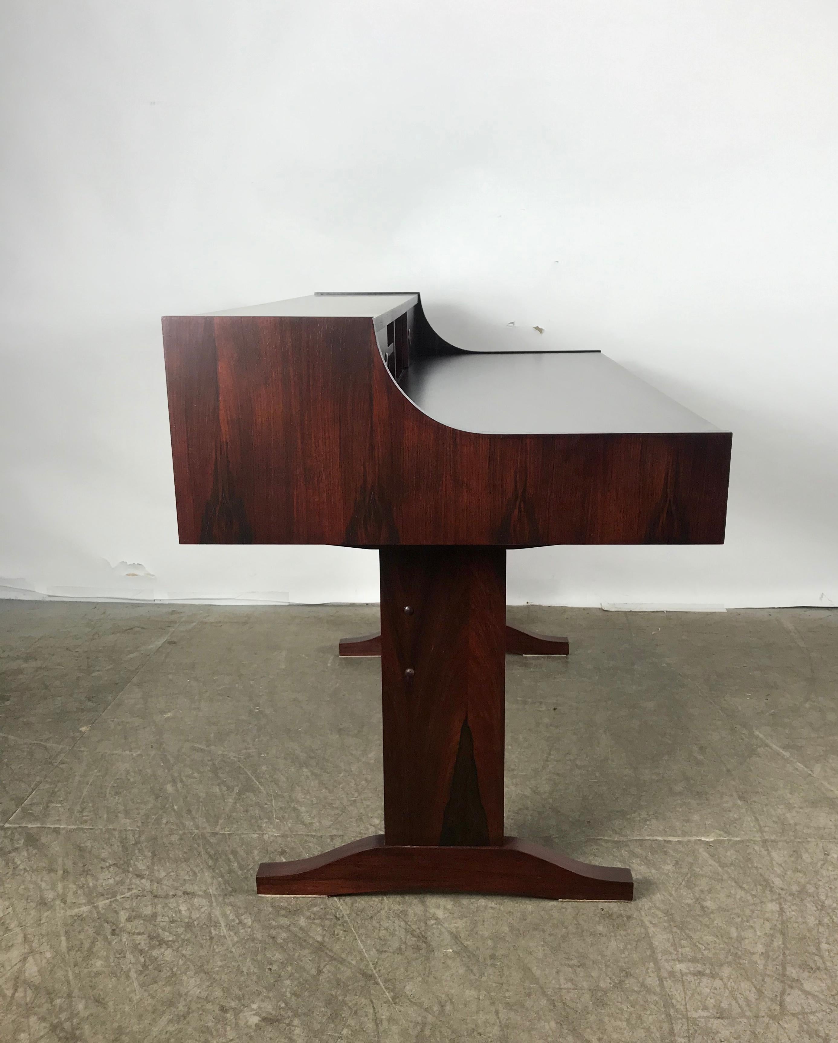 Stunning Danish modern Rosewood desk attributed to Peter Løvig Nielsen Dansk. Trestle design base. Generous work surface with two drawers. Step up cubbies with sliding doors. Professionally restored,refinished. Hand delivery avail to New York City