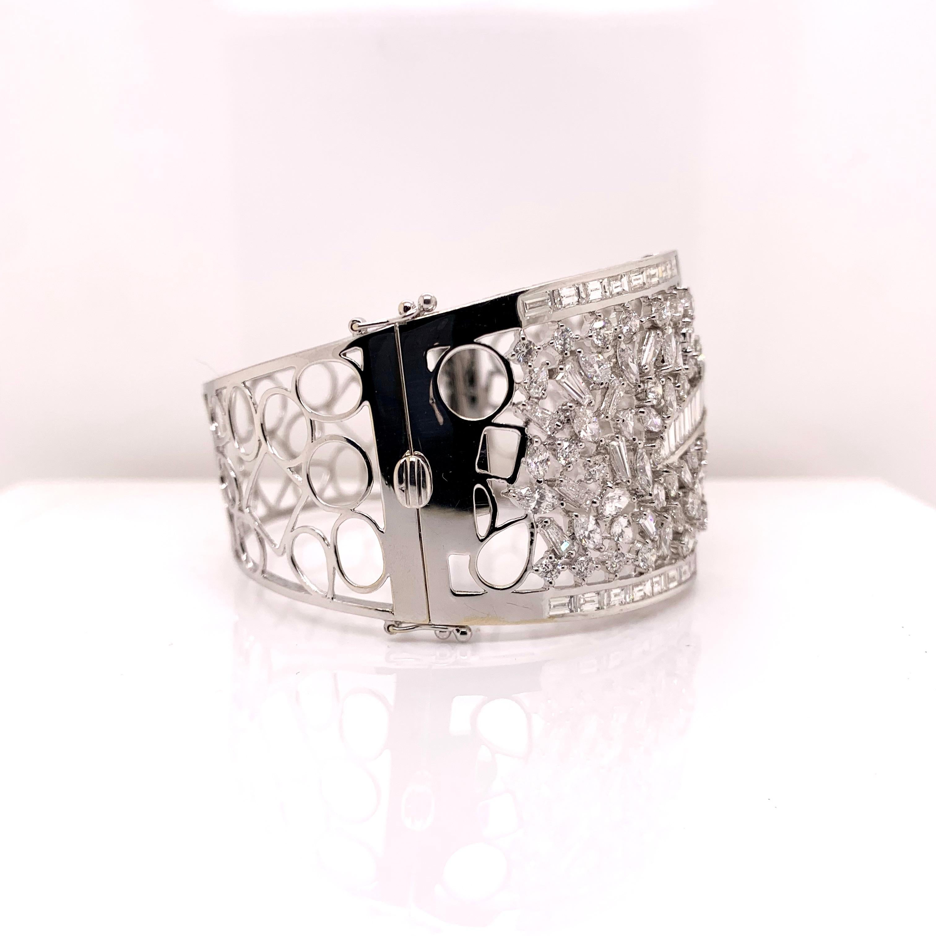 This wide diamond cuff is a statement piece!  This gorgeous cuff has an arrangement of round brilliant, baguette, marquise, and baguette diamonds that are tastefully arranged in this 18k white gold mounting.

Diamonds : 17.01 cts
Metal:  18k White