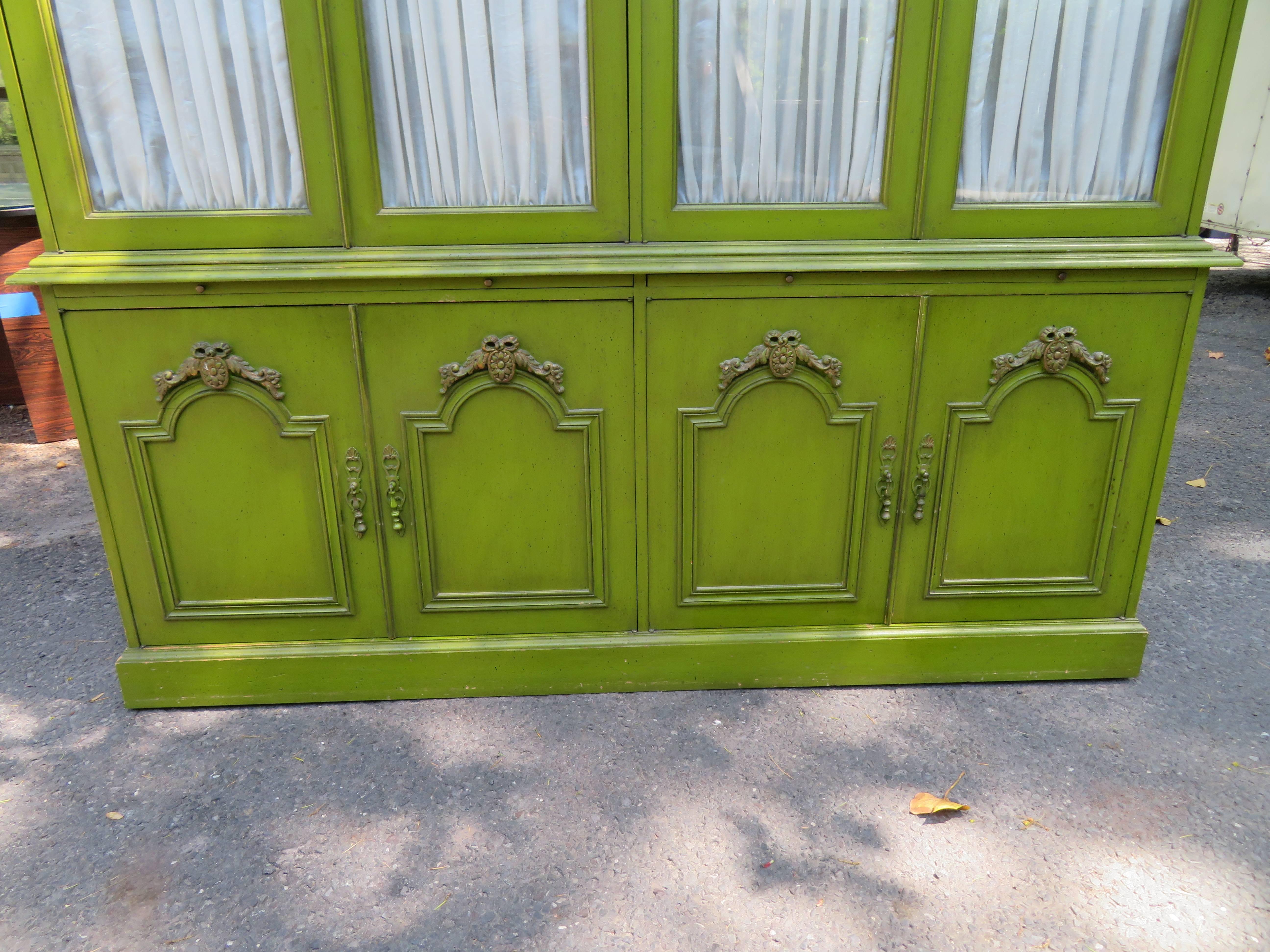 Magnificent Dorothy Draper style French Provincial hutch credenza. This piece is a show stopper with it's original lime green distressed finish and over the top quadruple arched top cabinet. Not sure if the curtains are original but they are well