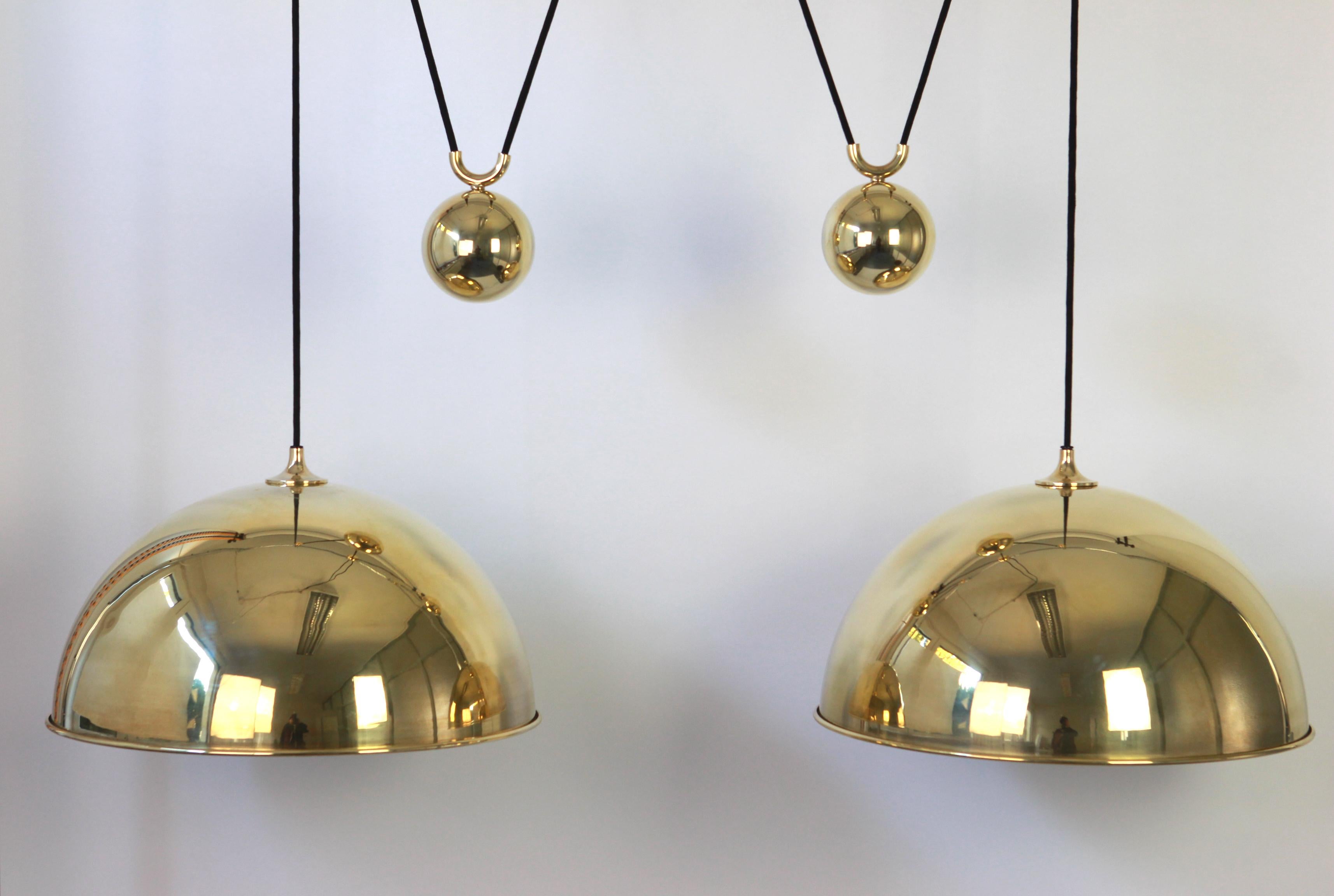 Stunning double Posa brass pendant with adjustable counter weights designed by Florian Schulz, Germany, 1970s

Two heavy metall ball counter-weight and two brass domes. Cloth cord.
Excellent vintage condition. Height is adjustable.
Sockets: 2 x