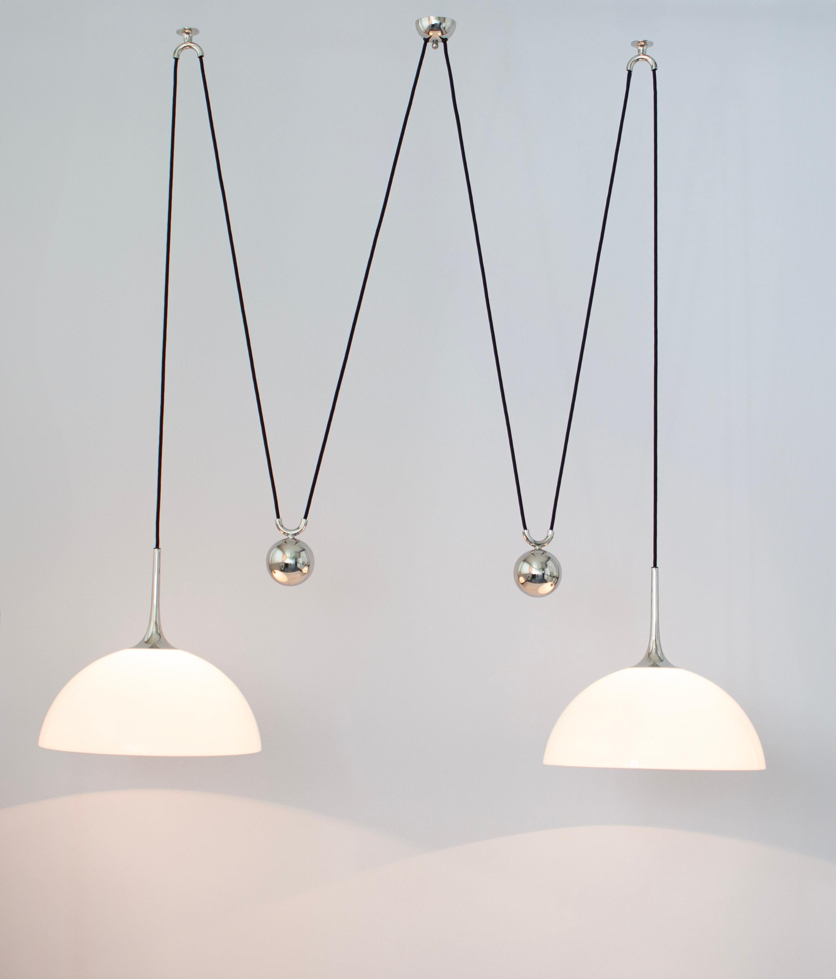 Stunning double Glass pendant with adjustable counterweights designed by Florian Schulz, Germany, 1970s

Two heavy metal ball counterweight and two Glass domes. Cloth cord.
Very vintage condition. Height is adjustable.
Sockets: 2 x E26/E27 standard