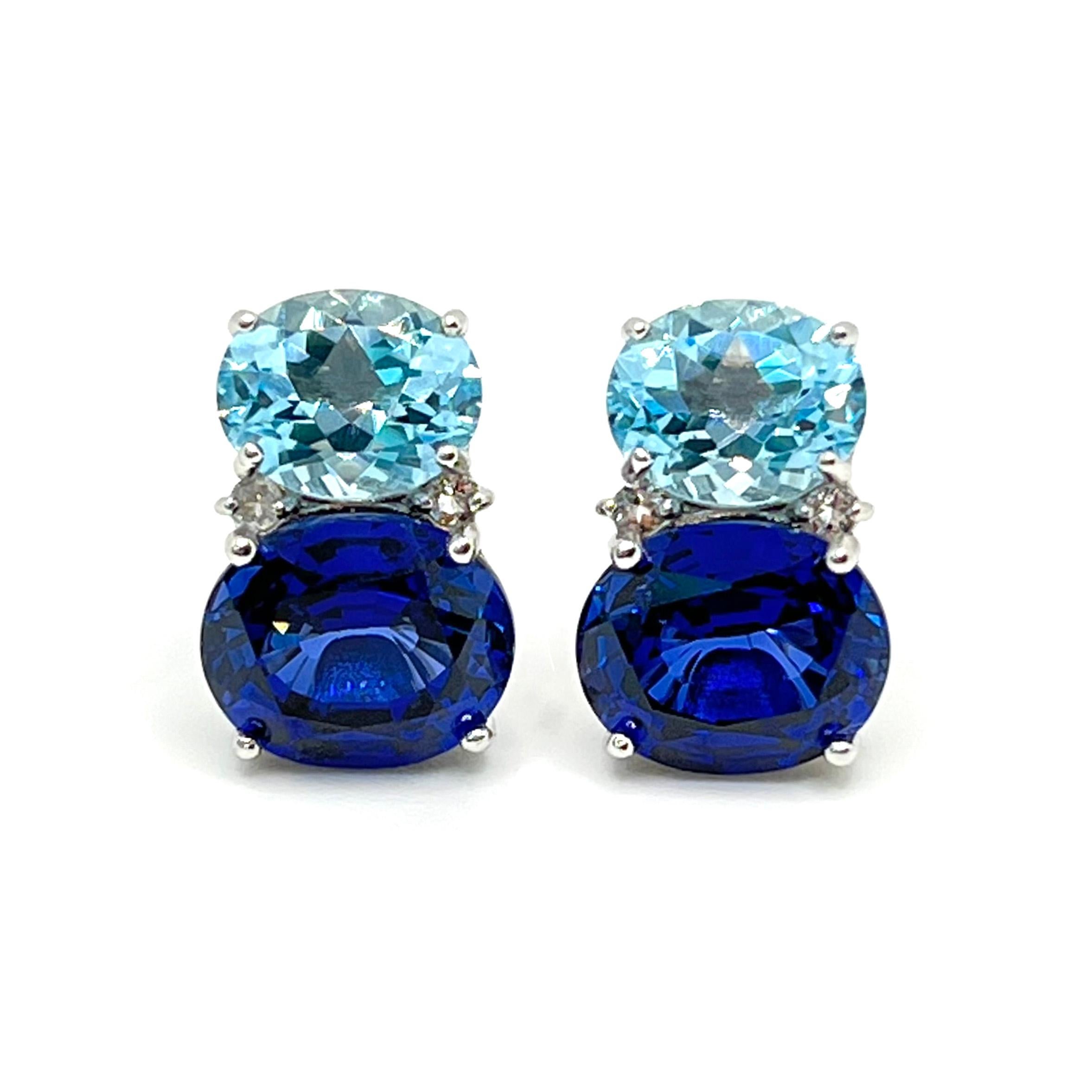These stunning pair of earrings features a pair of oval sky blue topaz, lab-created blue sapphire, adorned with round white topaz on the side, handset in platinum rhodium plated sterling silver. The two-tone blue combination just look so great