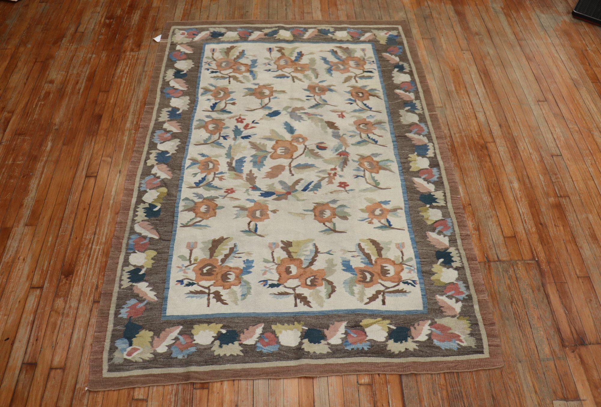 An early 20th century rustic color Bessarabian Kilim with a large scale floral design on an ivory field. The border and the field have floral motif s that intertwin.

Measures: 5'5” x 7'11”

Bessarabian Kilims in both pile and tapestry weaving