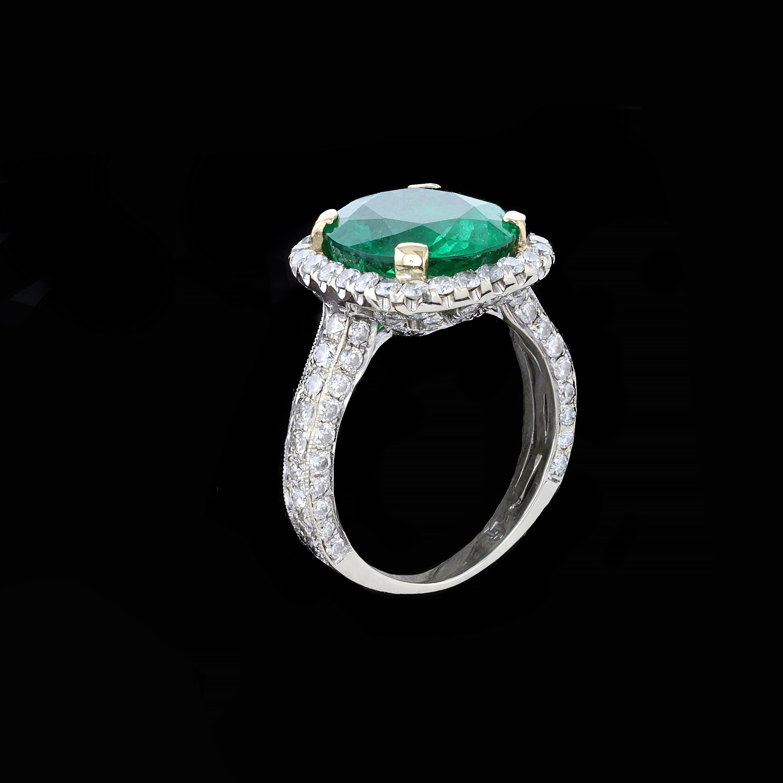 This stunning ring. has an 18kt white gold band with 18kt yellow gold prongs.

The center oval emerald is 4.55 cts surrounded by approximately 126 round diamonds totaling 2 ctt HI & SI1. It is size 4.75, but we can resize it for you.
