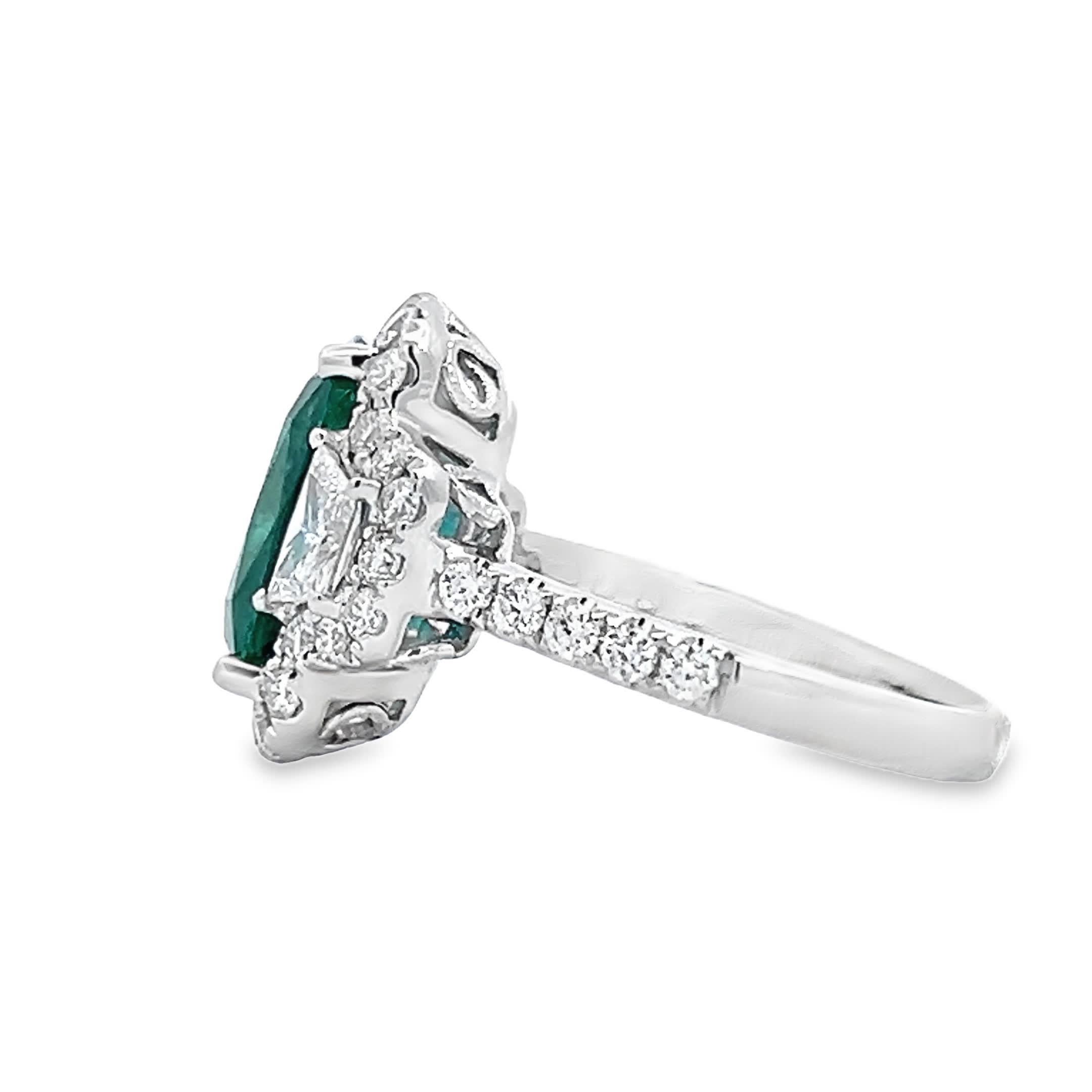 Dieser exquisite Ring besticht durch einen Smaragd in der Mitte, der von funkelnden Diamanten umgeben ist, die seine Schönheit unterstreichen. Das mit Präzision gefertigte Schmuckstück ist eine perfekte Mischung aus Eleganz und Luxus und damit die