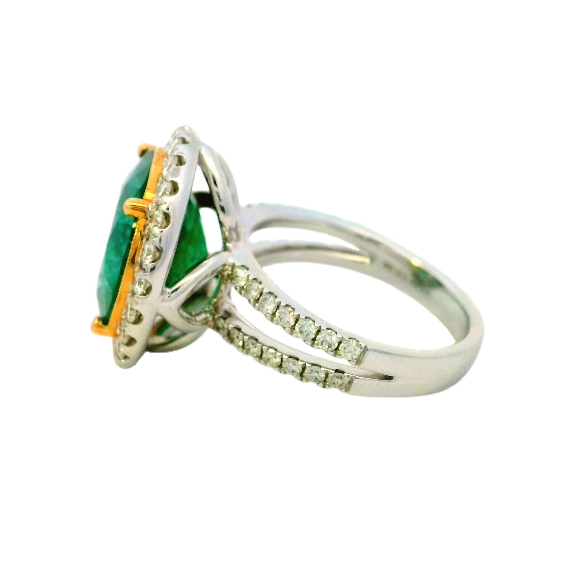 Dieser exquisite Ring zeigt in der Mitte einen leuchtenden Smaragd, der von einem Halo aus funkelnden Diamanten umgeben ist. Mit Präzision gefertigt, verkörpert sie Eleganz und Raffinesse und ist damit das perfekte Accessoire für jeden Anlass. Ganz