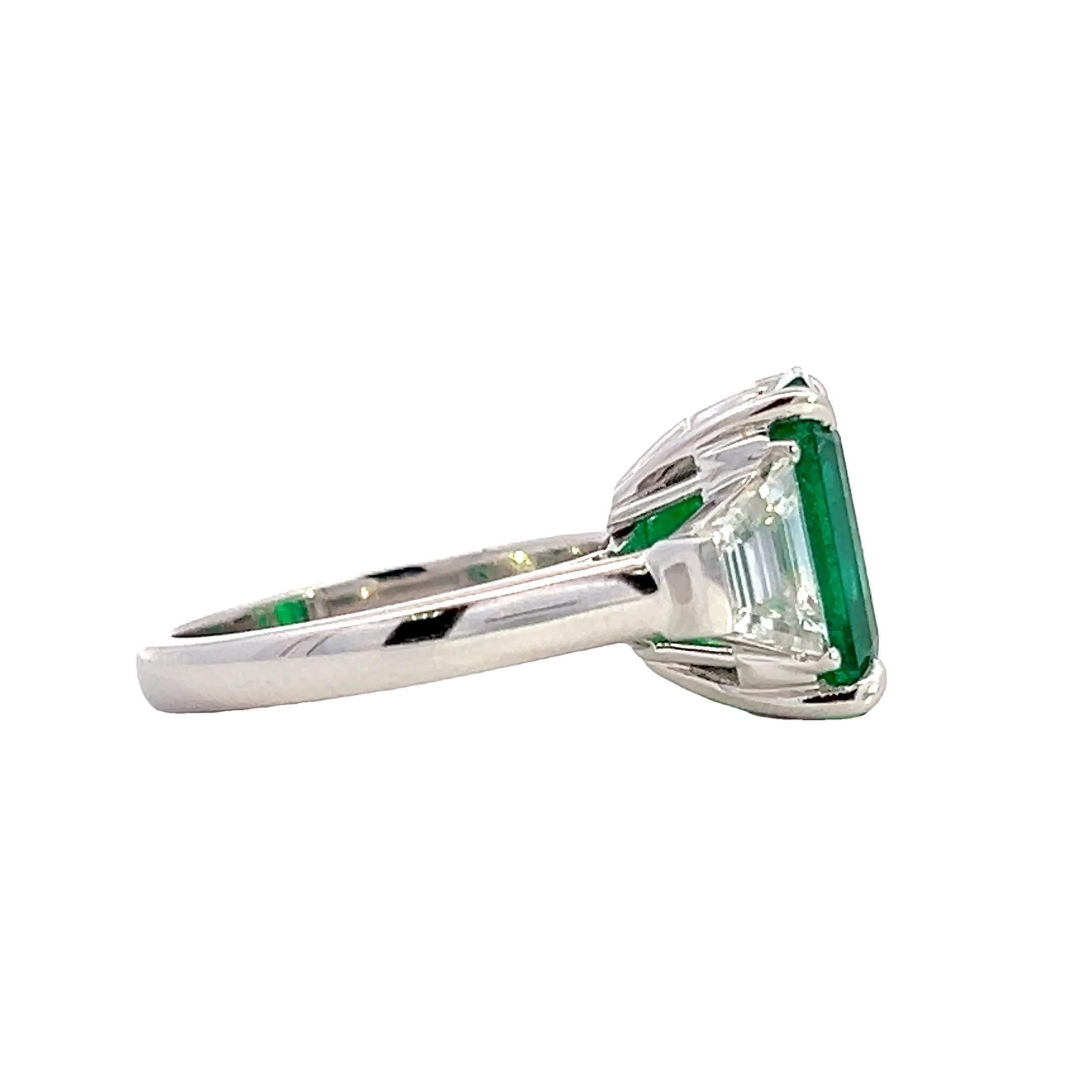 Dieser exquisite Ring hat einen leuchtenden Smaragd in der Mitte, der von funkelnden Diamanten umgeben ist, die seinen Charme noch verstärken. Das mit Präzision gefertigte Design bringt den satten Grünton des Smaragds zur Geltung und ist damit ein