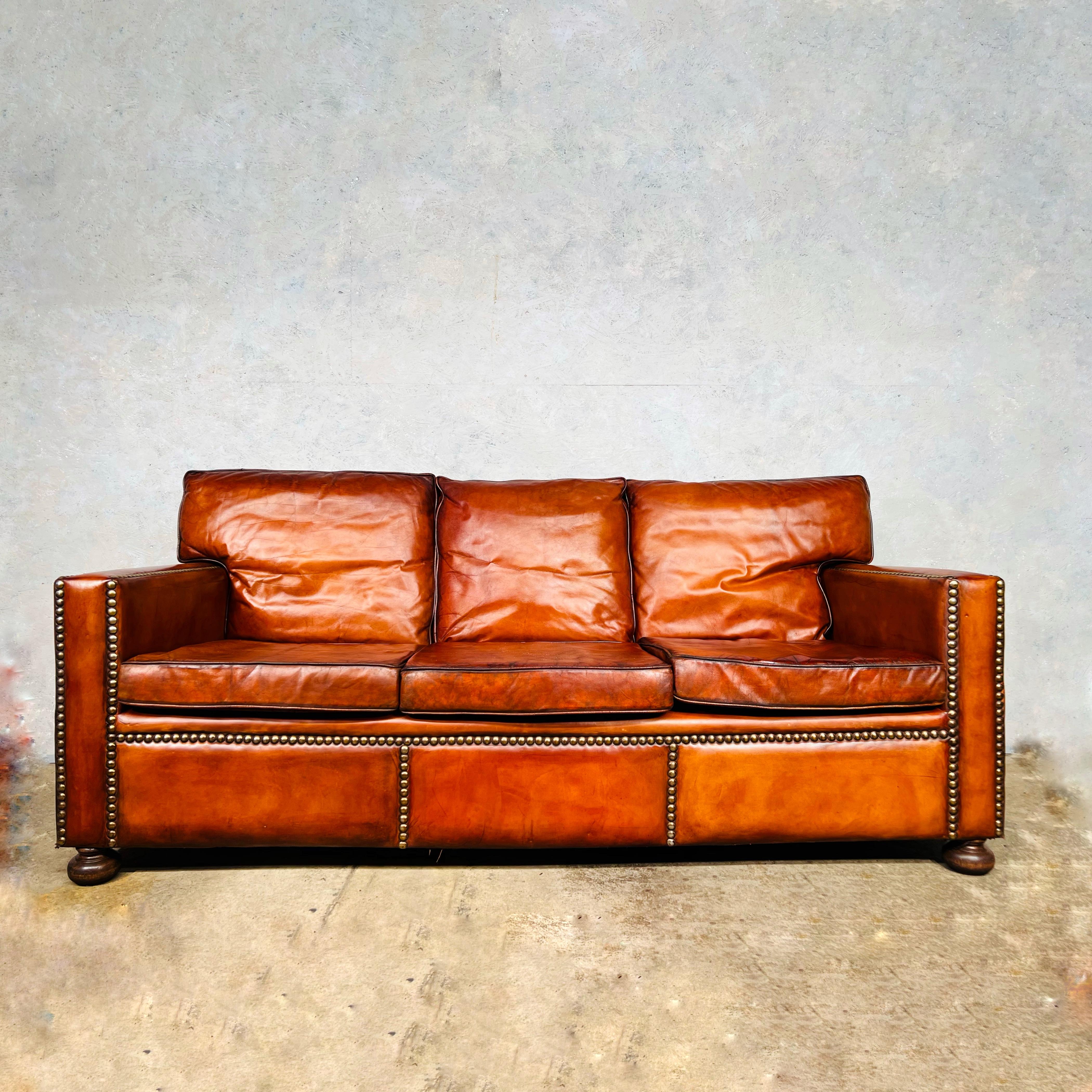 Stunning English midcentury chestnut brown leather studded three seater sofa.

Very stylish with a beautiful shape with great quality leather and feather filled cushions, in great vintage condition, restored and hand dyed a beautiful tan colour