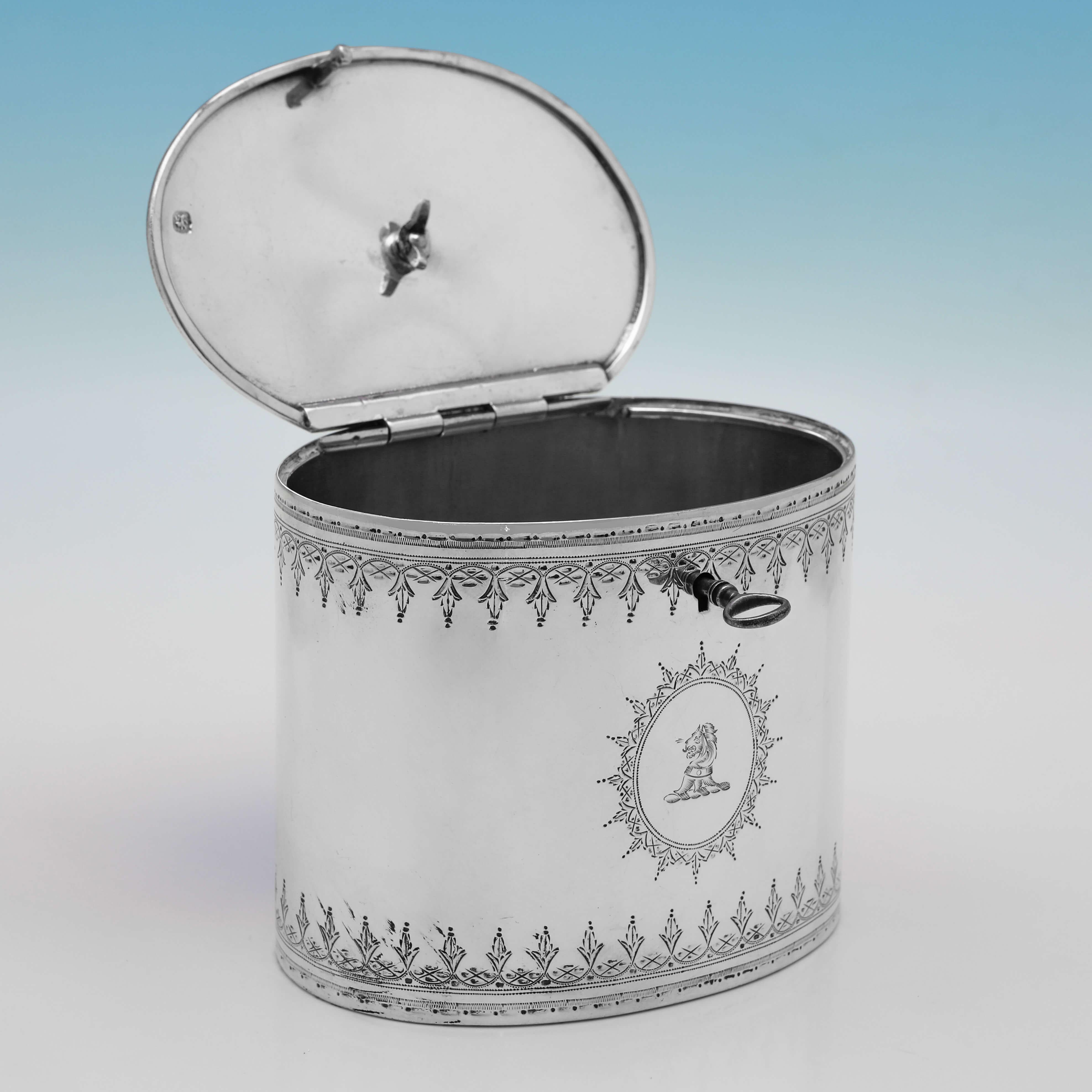 Hallmarked in London in 1806 by Thomas Paine Dexter, this charming, George III period, Antique Sterling Silver Tea Caddy, is oval in shape, and in the Neoclassical taste, with bright cut engraved decoration to the body and lid, a tea plant finial,